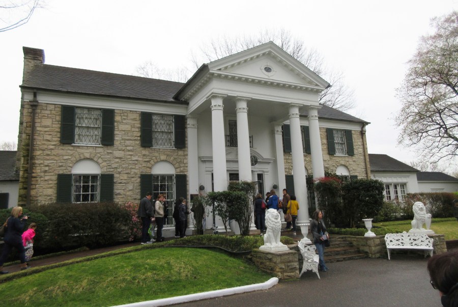 FILE - This March 13, 2017 photo shows visitors getting ready to tour Graceland in Memphis, Tenn. The head of the company that controls Graceland says he is not threatening to move the Memphis, Tennessee-based tourist attraction centered on the life of singer Elvis Presley if city officials do not approve an expansion plan including tax-based incentives. (AP Photo/Beth J. Harpaz, File)
