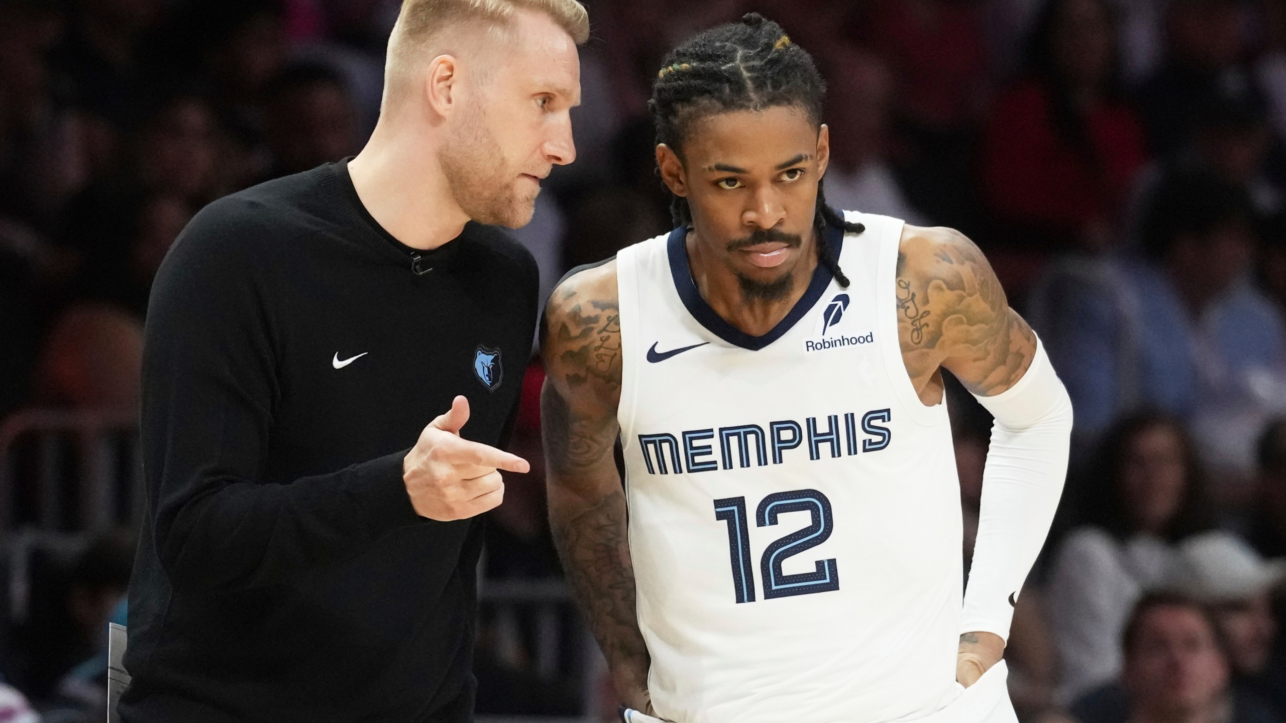 Memphis Grizzlies interim head coach Tuomas Lisalo talks to guard Ja Morant (12) during the second half of an NBA basketball game, Thursday, April 3, 2025, in Miami. (AP Photo/Marta Lavandier)