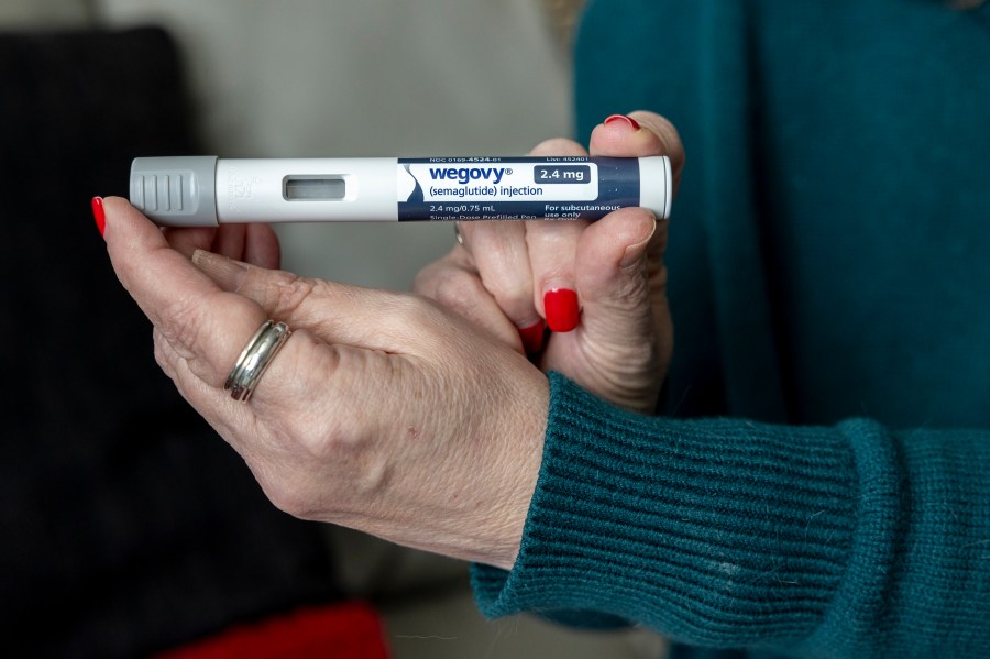 FILE - Donna Cooper holds up a dosage of Wegovy, a drug used for weight loss, at her home in Front Royal, Va., on Friday, March 1, 2024. (AP Photo/Amanda Andrade-Rhoades, File)
