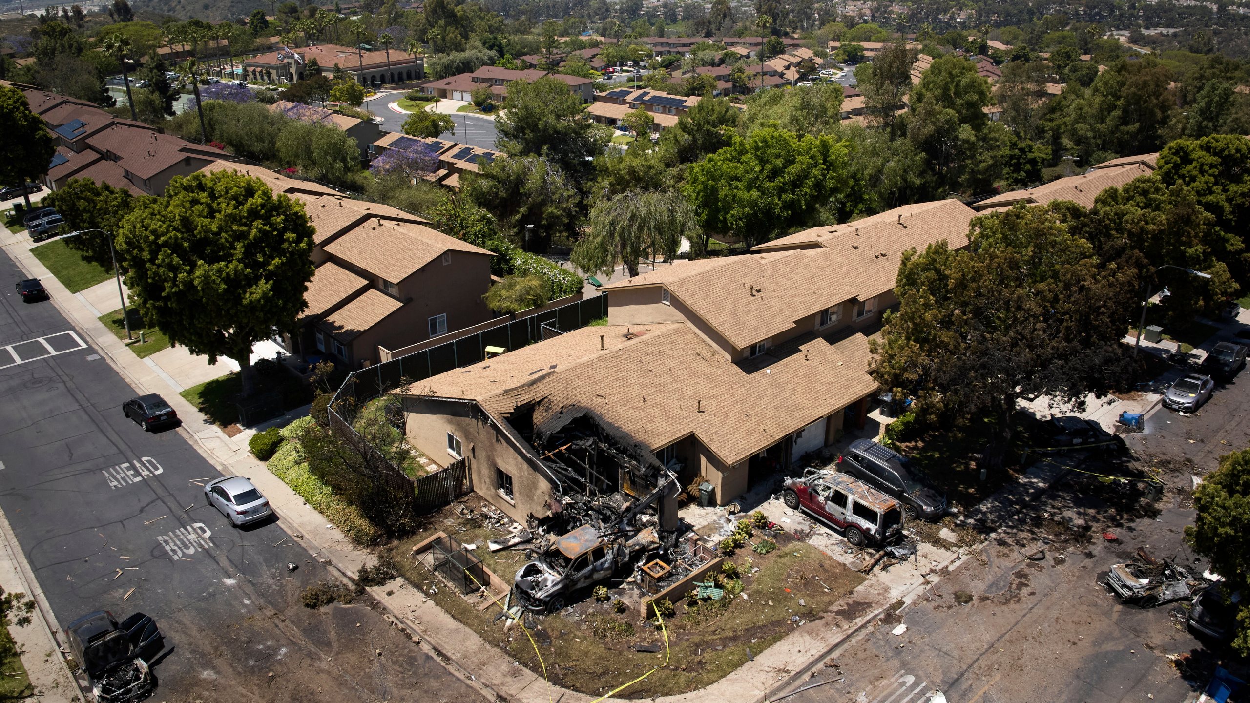 Debris covers the ground after a small plane crashed into a San Diego neighborhood, setting homes and cars on fire and forcing evacuations early Thursday, May 22, 2025. (AP Photo/William Liang)