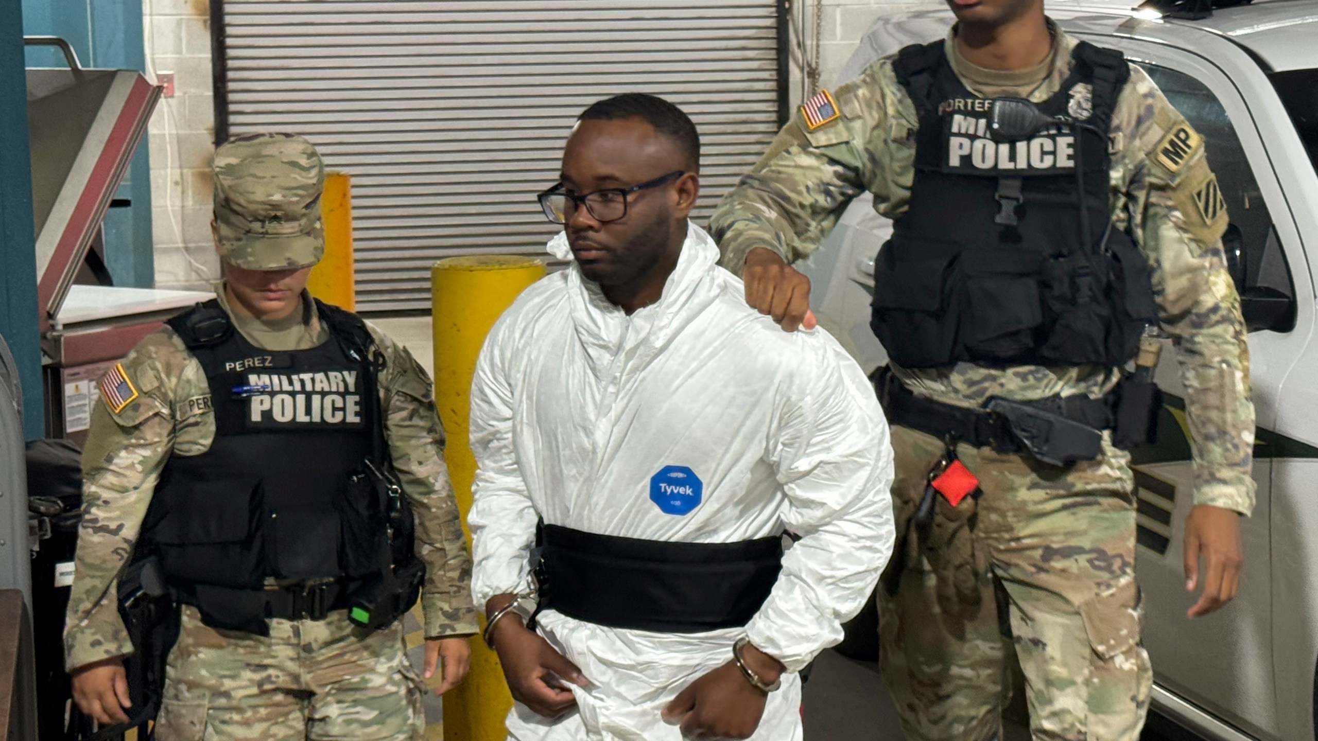 Sgt. Quornelius Radford, a suspect in the shooting of five soldiers at Fort Stewart, is escorted by military police into a booking room at the Liberty County Jail in Hinesville, Ga., Wednesday, Aug. 6, 2025. (AP Photo/Lewis M. Levine)