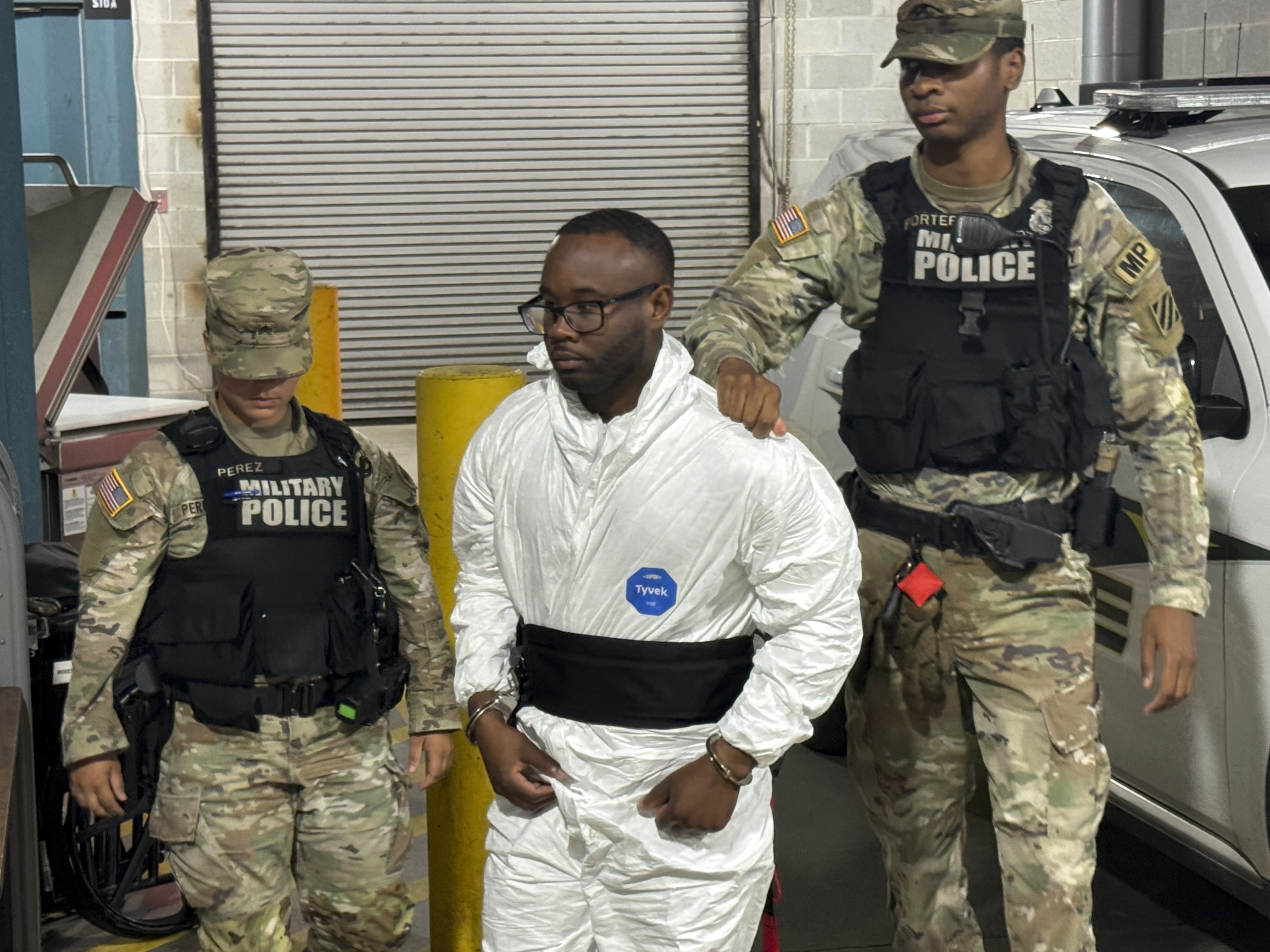Sgt. Quornelius Radford, a suspect in the shooting of five soldiers at Fort Stewart, is escorted by military police into a booking room at the Liberty County Jail in Hinesville, Ga., Wednesday, Aug. 6, 2025. (AP Photo/Lewis M. Levine)