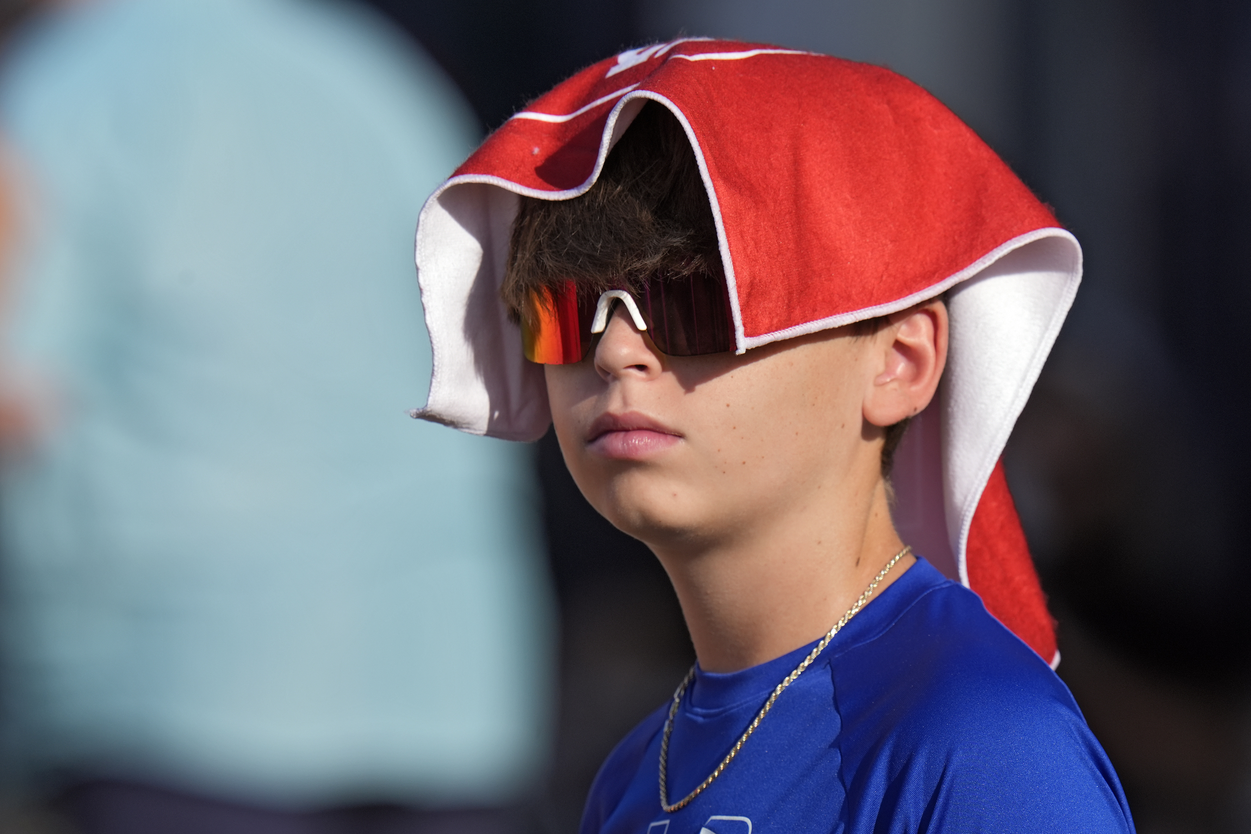 FILE - A young Tampa Bay Buccaneers fan covers his head to avoid the sun and heat during Back Together Weekend at an NFL football training camp practice Sunday, July 27, 2025, in Tampa, Fla. (AP Photo/Chris O'Meara, File)