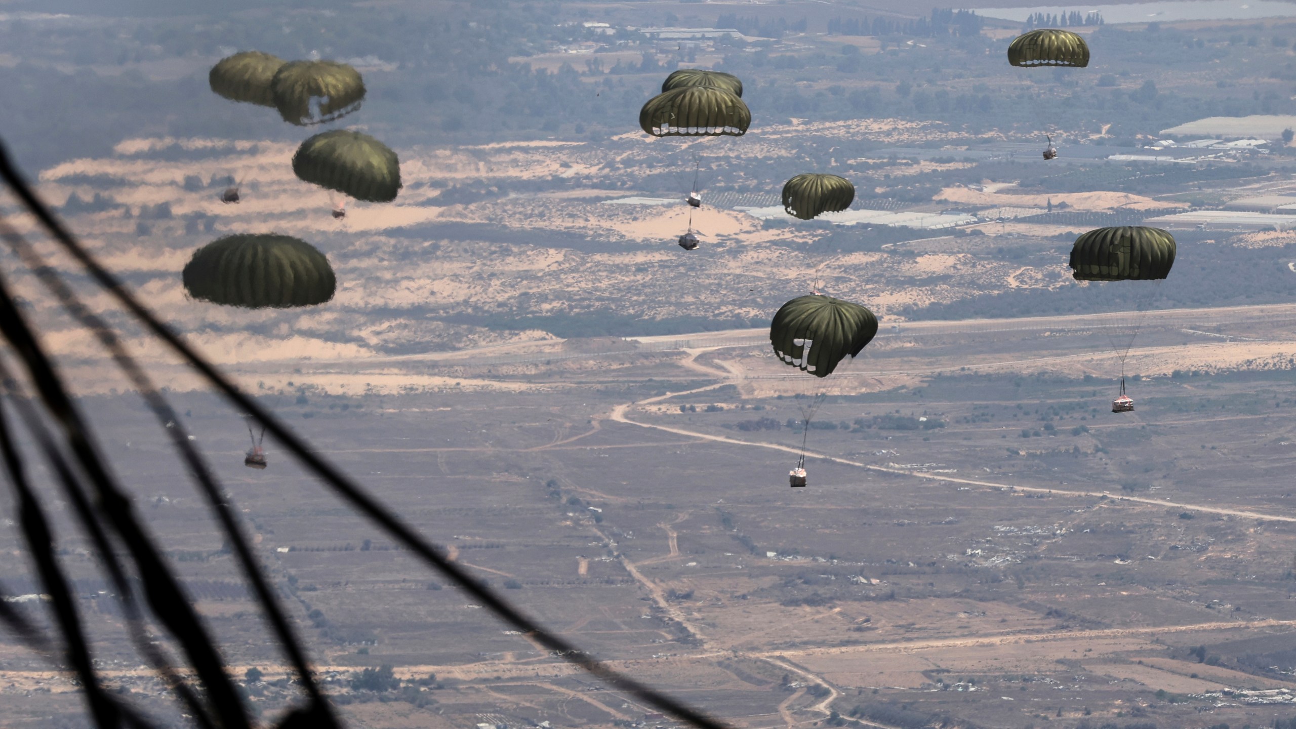 Containers of humanitarian aid are airdropped to Palestinians in the Gaza Strip from a Jordanian Air Force C-130 plane, Thursday, Aug. 7, 2025. (AP Photo/Raad Adayleh)