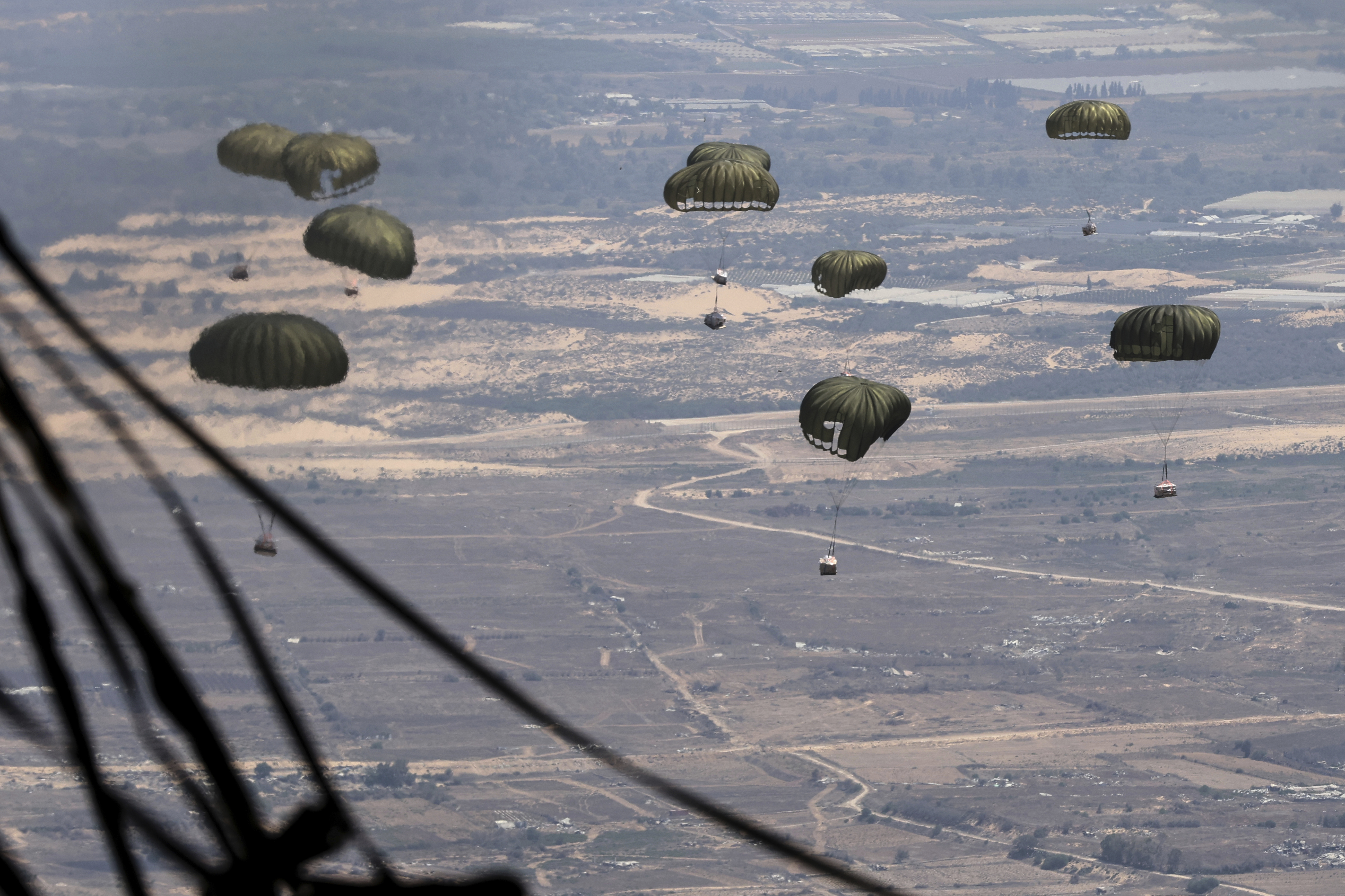 Containers of humanitarian aid are airdropped to Palestinians in the Gaza Strip from a Jordanian Air Force C-130 plane, Thursday, Aug. 7, 2025. (AP Photo/Raad Adayleh)
