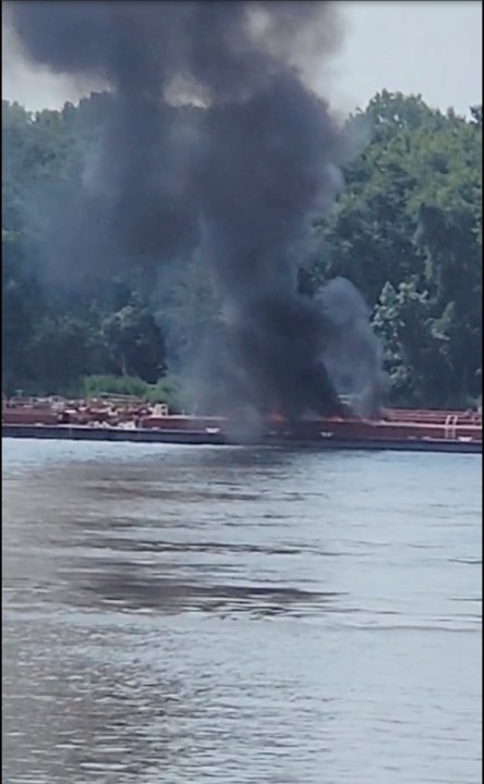 This image provided by Adam Briggs shows smoke fills the air from a barge after a helicopter crash in the Mississippi River near Alton, Ill., on Thursday, Aug. 7, 2025. (Adam Briggs via AP)