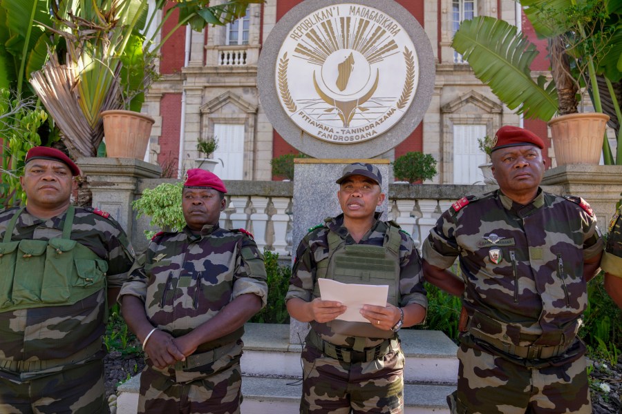 CAPSAT military unit commander Col. Michael Randrianirina, center, reads a statement saying that the armed forces are taking control of the country from the steps of the Presidency in Antananarivo, Madagascar, Tuesday, Oct. 14, 2025. (AP Photo/ Brian Inganga)