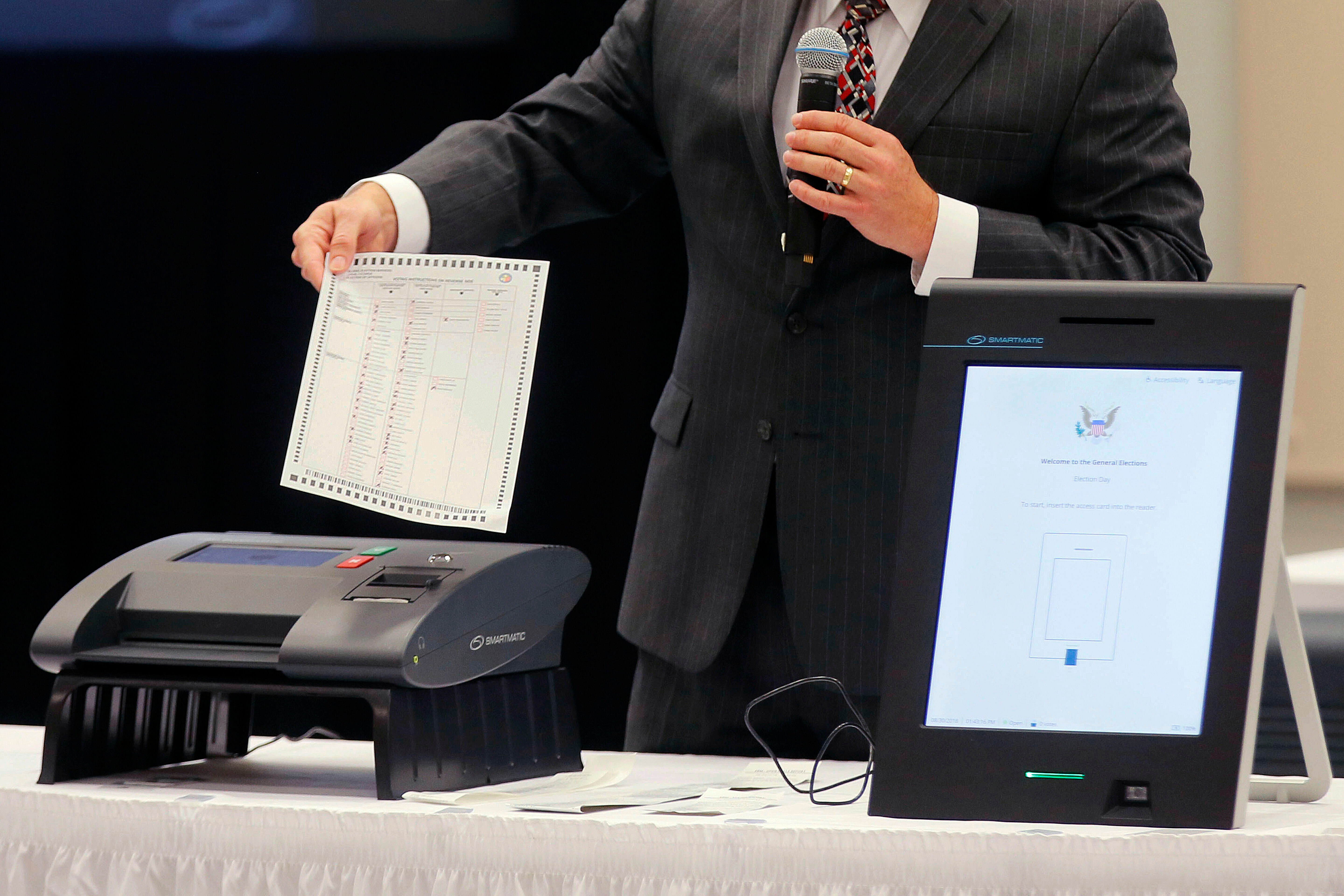 FILE - A Smartmatic representative demonstrates his company's system which has scanners and touch screens with printout options, at a meeting of the Secure, Accessible & Fair Elections Commission, Aug. 30, 2018, in Grovetown, Ga. (Bob Andres/Atlanta Journal-Constitution via AP, File)