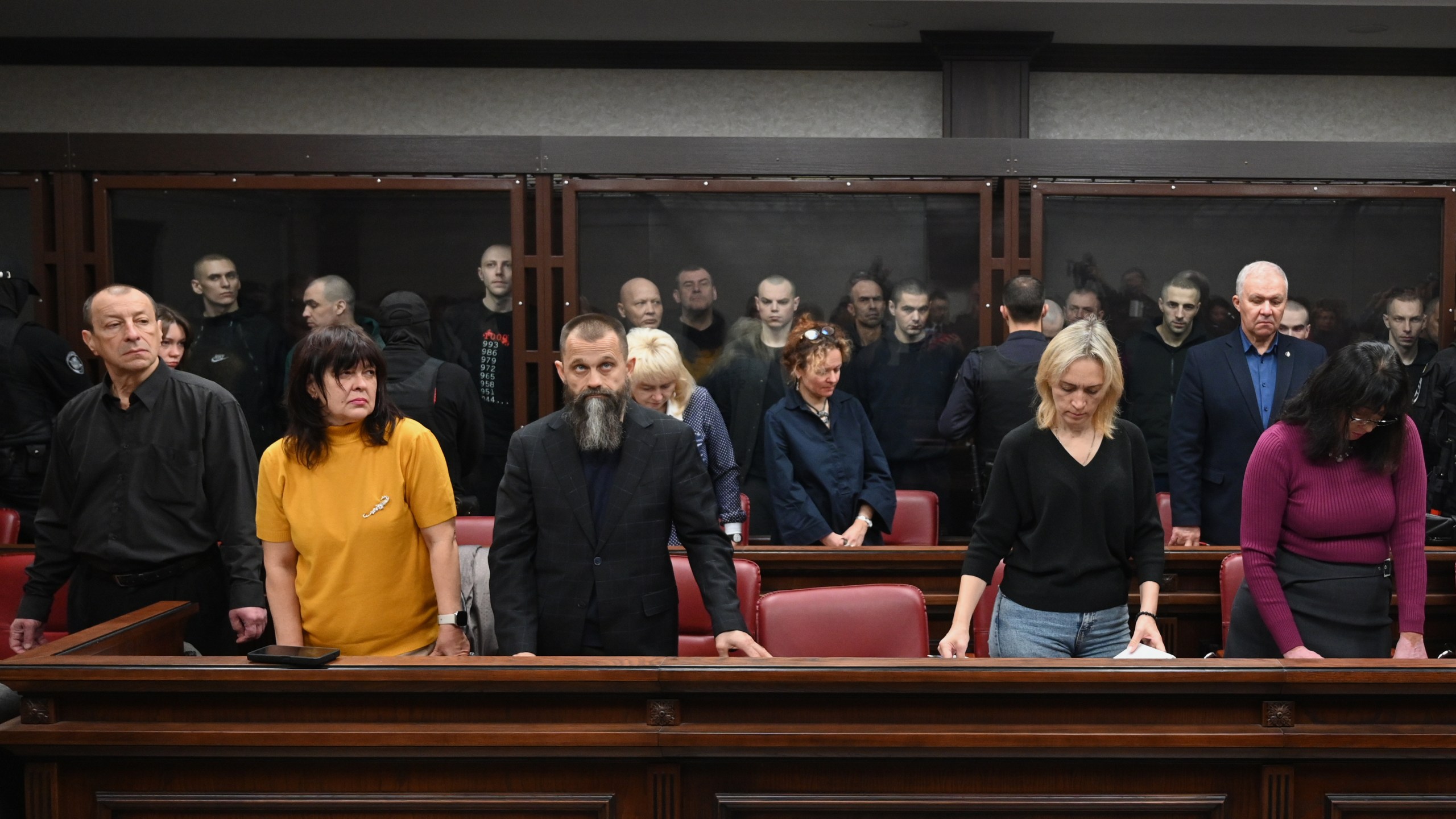 Lawyers of Ukrainian soldiers of the Aidar battalion captured by Russia during fighting in Ukraine stand in front of the defendants' cage during a hearing at the Southern District Military Court in Rostov-on-Don, Russia, Friday, Oct. 17, 2025. (AP Photo)