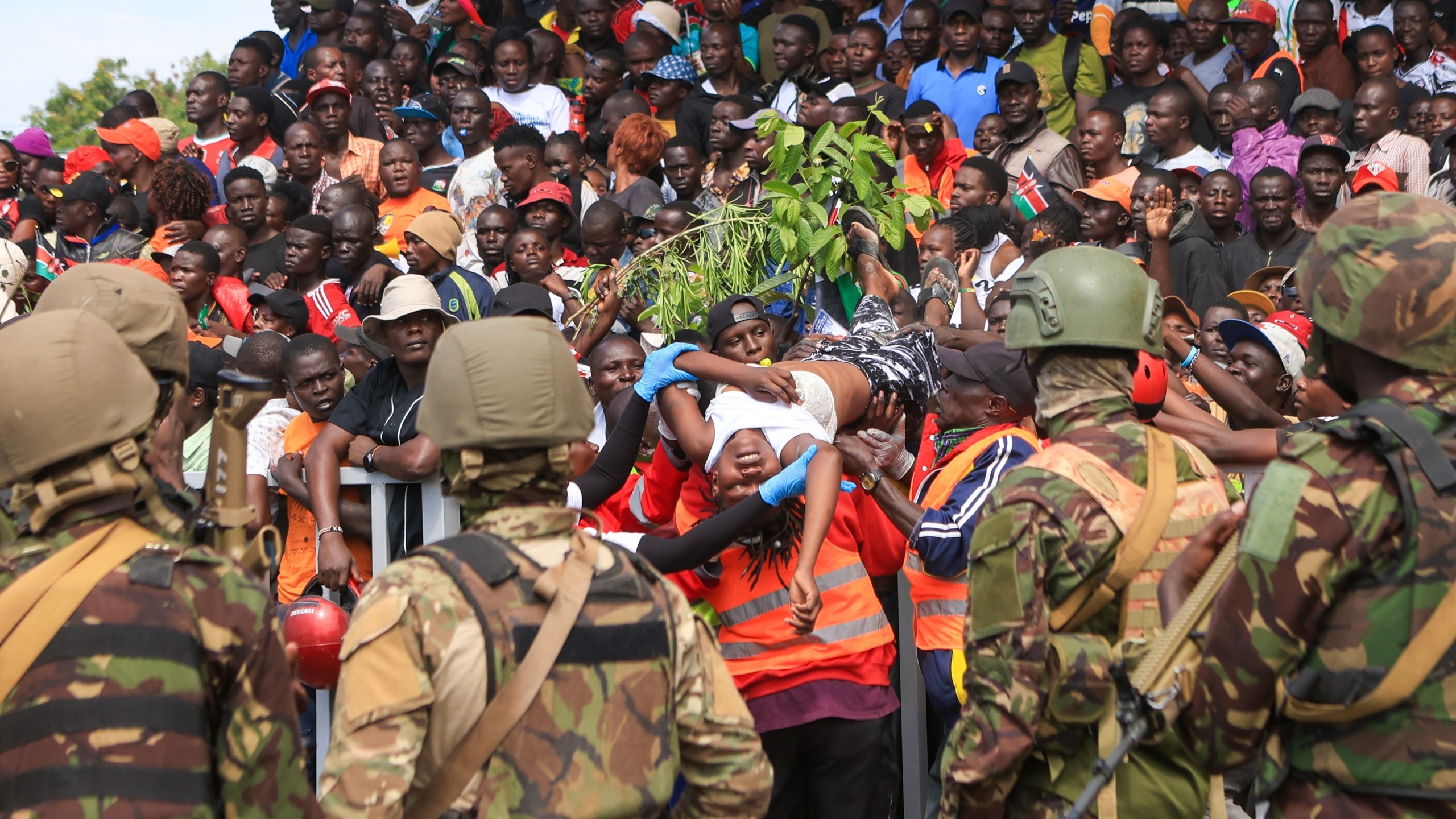 A woman is evacuated after fainting during the viewing of the body of former Kenya Prime Minister Raila Odinga at Jomo Kenyatta Stadium in Kisumu, Kenya, Saturday, Oct. 18, 2025. (AP Photo/Andrew Kasuku)