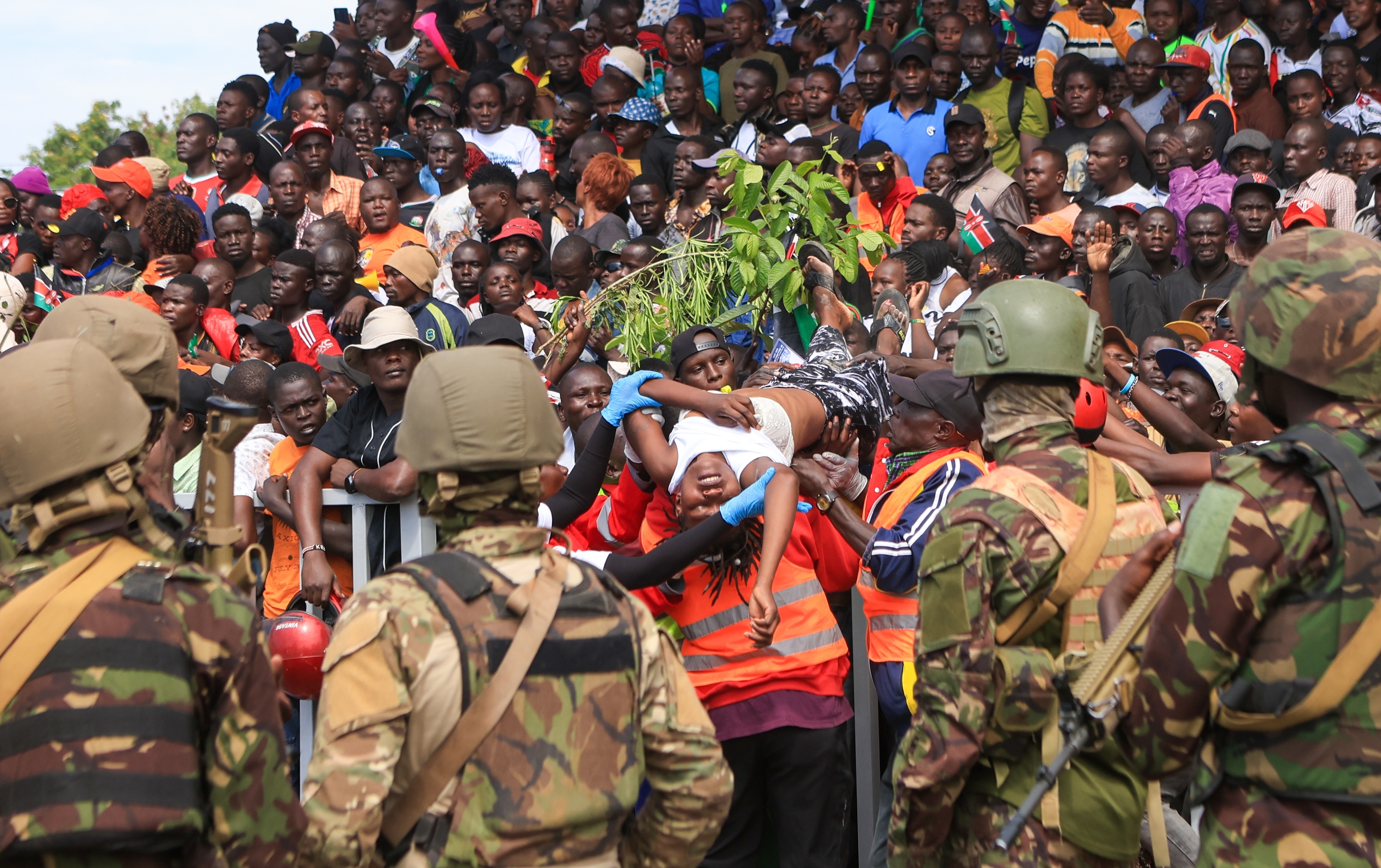 A woman is evacuated after fainting during the viewing of the body of former Kenya Prime Minister Raila Odinga at Jomo Kenyatta Stadium in Kisumu, Kenya, Saturday, Oct. 18, 2025. (AP Photo/Andrew Kasuku)