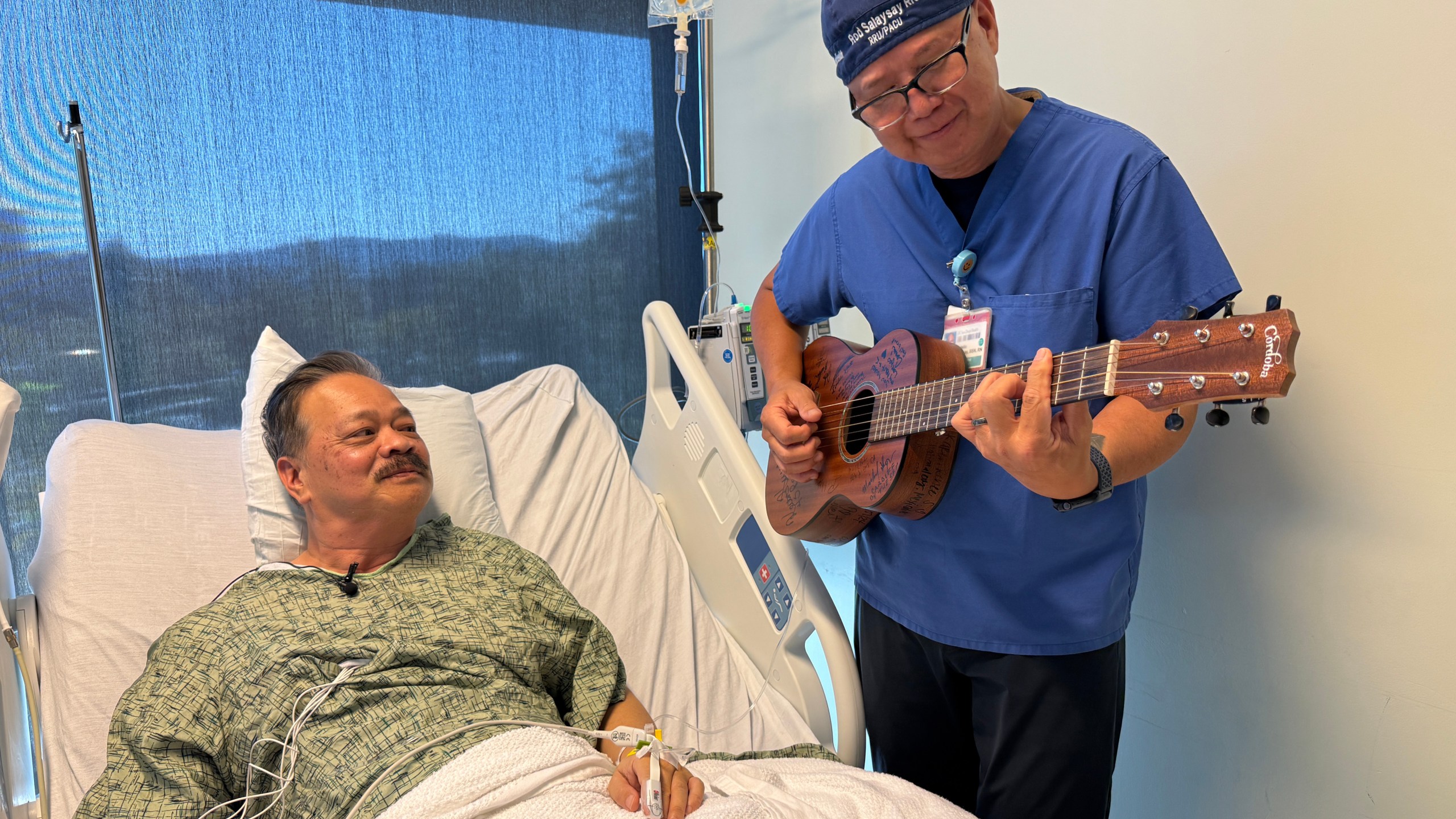 Nurse Rod Salaysay plays guitar for patient Richard Hoang in the recovery unit of UC San Diego Health in San Diego, Calif., on Sept. 30, 2025. (AP Photo/Javier Arciga)