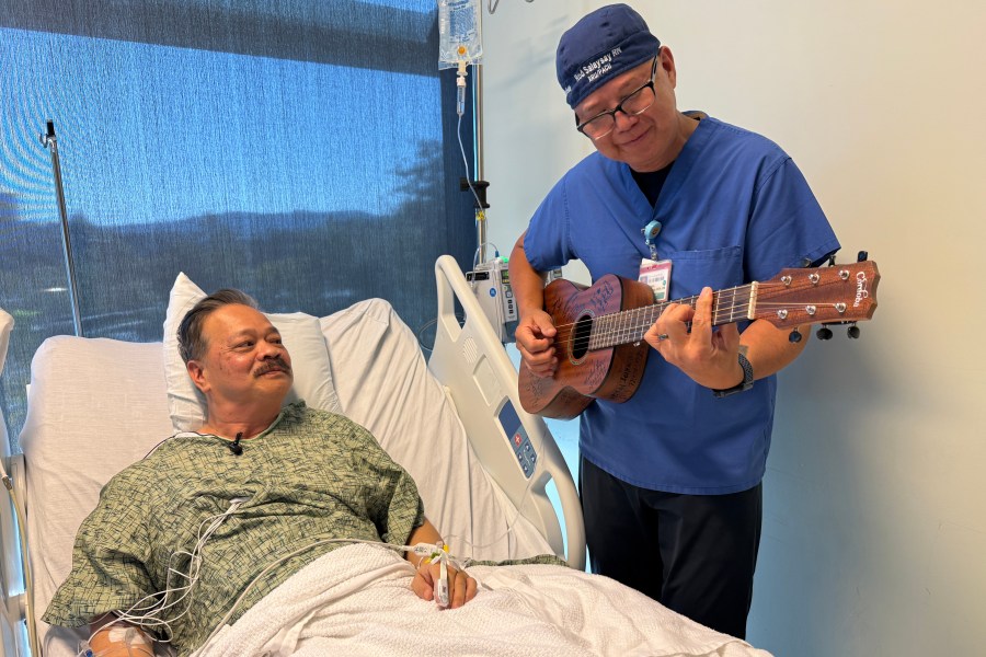 Nurse Rod Salaysay plays guitar for patient Richard Hoang in the recovery unit of UC San Diego Health in San Diego, Calif., on Sept. 30, 2025. (AP Photo/Javier Arciga)