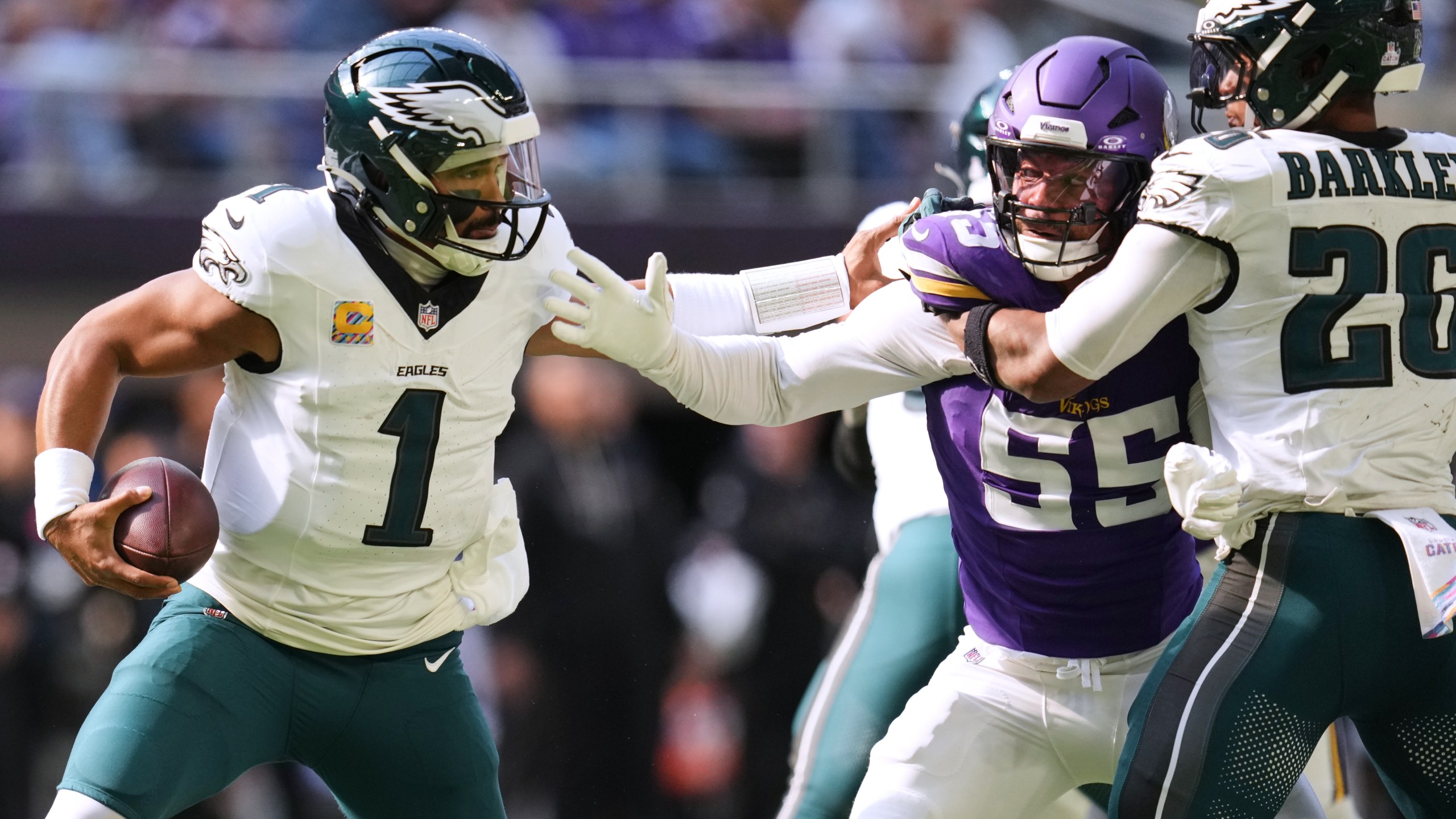 Philadelphia Eagles quarterback Jalen Hurts (1) tries to avoid a tackle from Minnesota Vikings linebacker Eric Wilson (55) during the first half of an NFL football game Sunday, Oct. 19, 2025, in Minneapolis. (AP Photo/Abbie Parr)