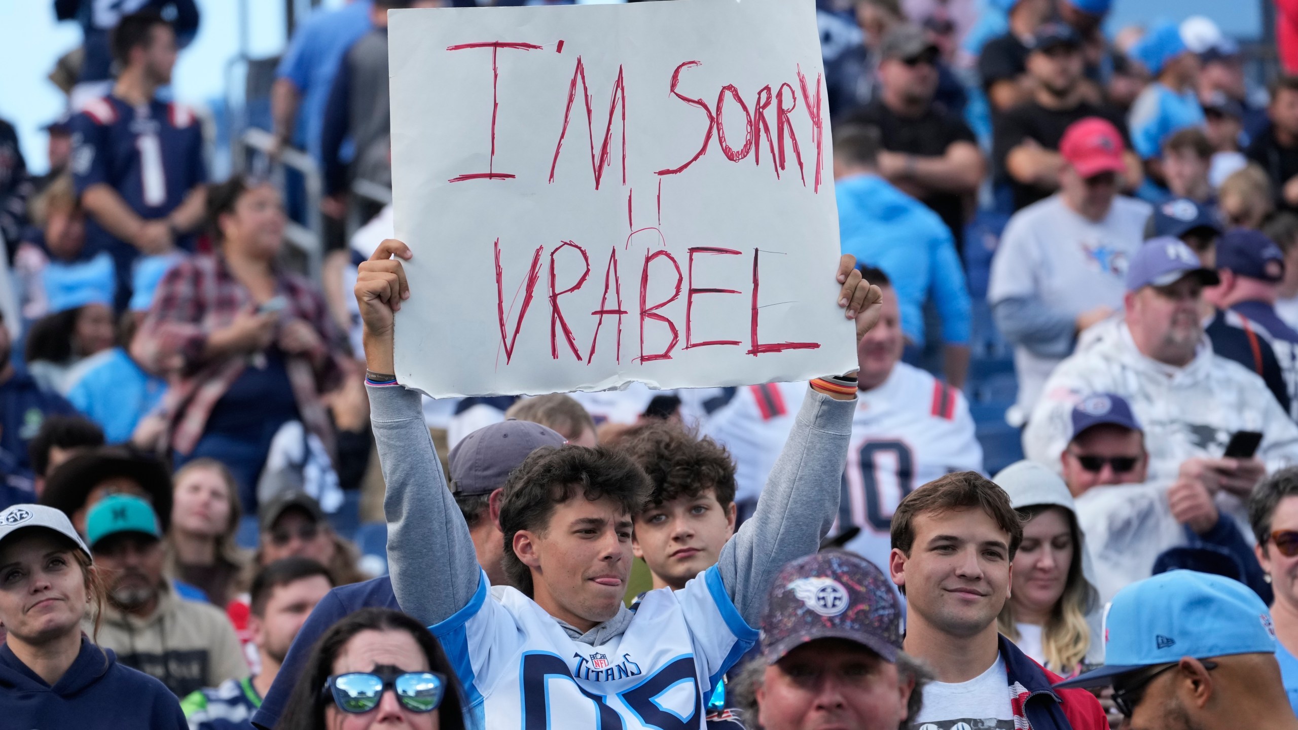 A Tennessee Titans fans holds up a sign during the second half of an NFL football game against the New England Patriots, Sunday, Oct. 19, 2025, in Nashville, Tenn. (AP Photo/George Walker IV)