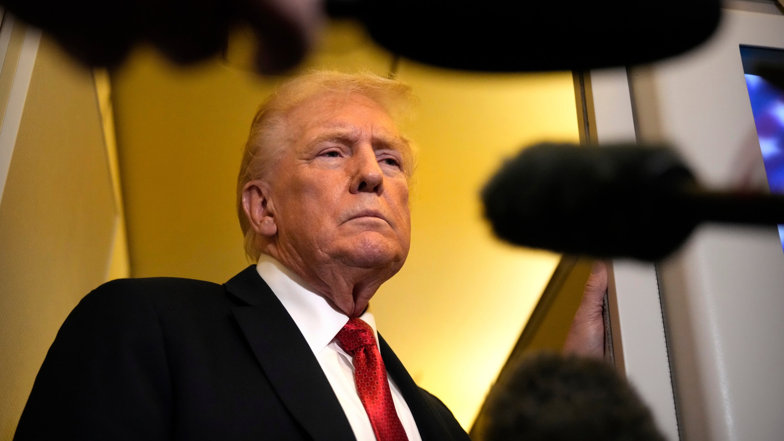 President Donald Trump speaks to reporters aboard Air Force One, Sunday, Oct. 19, 2025, en route to Joint Base Andrews, Md., as he returns from a trip to Florida. (AP Photo/Mark Schiefelbein)