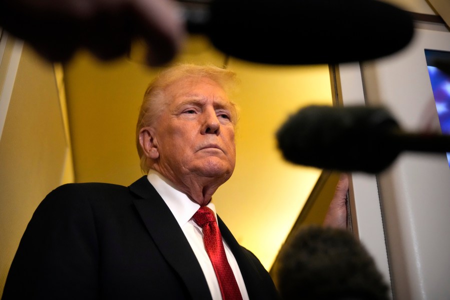 President Donald Trump speaks to reporters aboard Air Force One, Sunday, Oct. 19, 2025, en route to Joint Base Andrews, Md., as he returns from a trip to Florida. (AP Photo/Mark Schiefelbein)