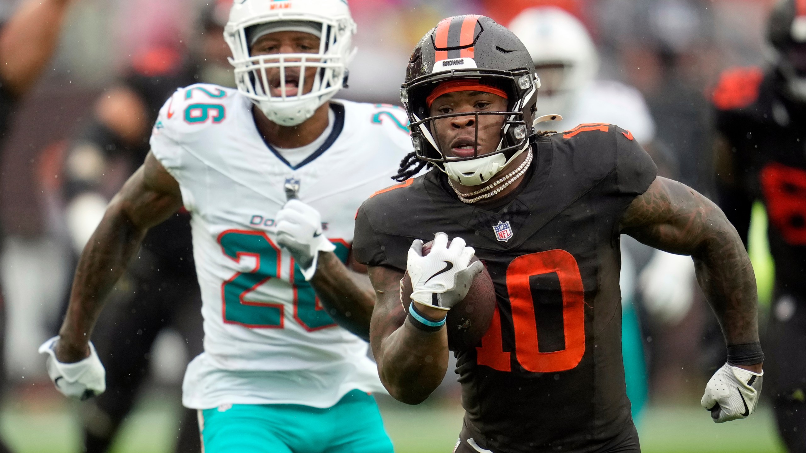 Cleveland Browns running back Quinshon Judkins (10) carries the ball ahead of Miami Dolphins cornerback Rasul Douglas (26) in the first half of an NFL football game in Cleveland, Sunday, Oct. 19, 2025. (AP Photo/Sue Ogrocki)