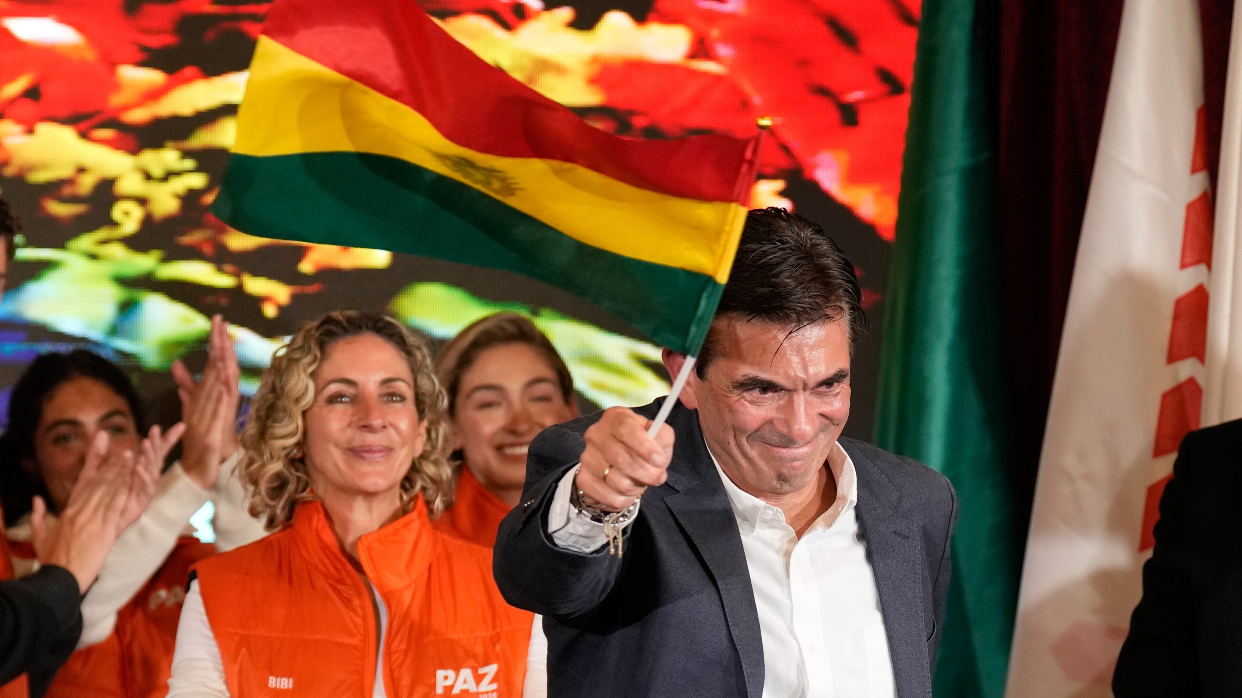Presidential candidate Rodrigo Paz waves a Bolivian flag after preliminary results showed him leading in the presidential runoff election in La Paz, Bolivia, Sunday, Oct. 19, 2025. (AP Photo/Natacha Pisarenko)