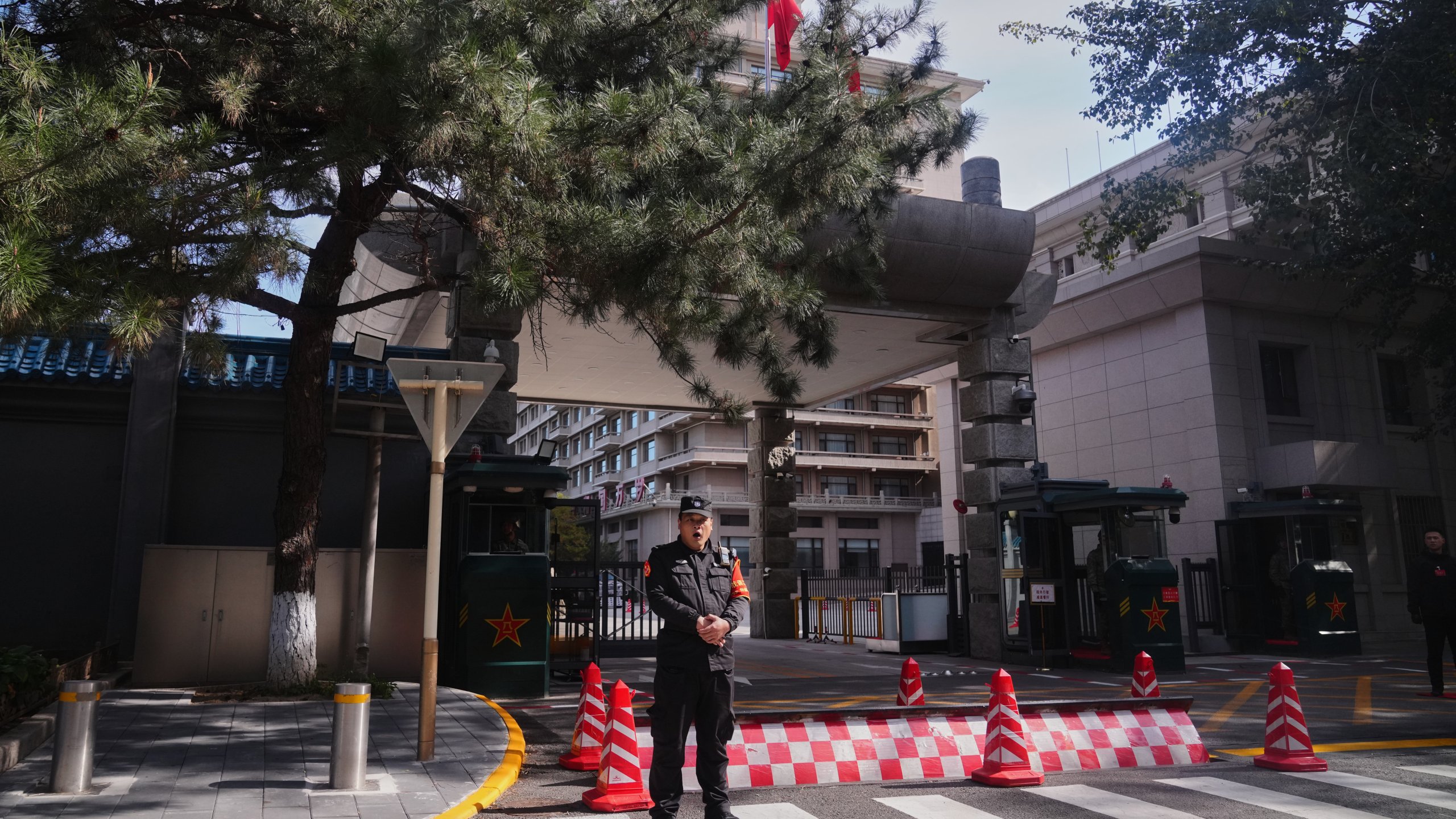 A Chinese security person yawns as he stands guard at the entrance gate to the Jingxi Hotel where the Communist Party's Central Committee is holding its fourth plenum, in Beijing, Monday, Oct. 20, 2025. (AP Photo/Andy Wong)