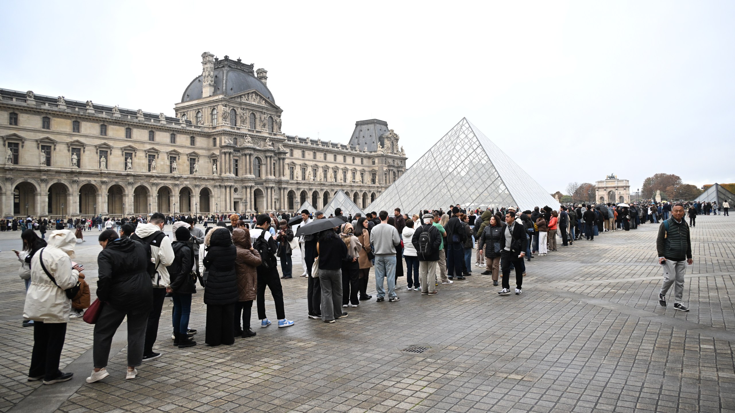 People queue outside the Louvre museum that remains closed for the day after Sunday's jewels robbery, Monday, Oct. 20, 2025 in Paris. (AP Photo/Emma Da Silva)