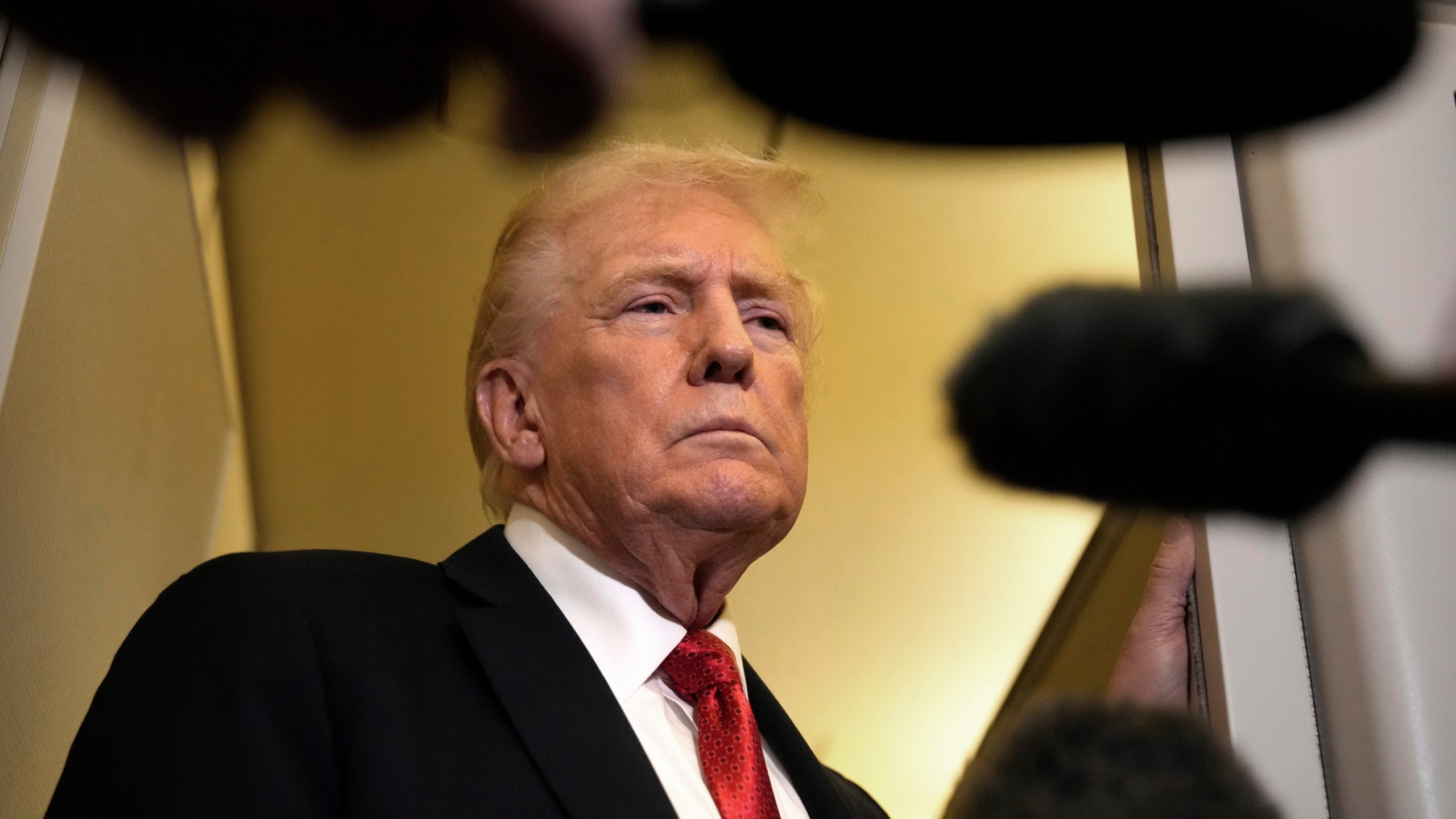 President Donald Trump speaks to reporters aboard Air Force One, Sunday, Oct. 19, 2025, en route to Joint Base Andrews, Md., as he returns from a trip to Florida. (AP Photo/Mark Schiefelbein)