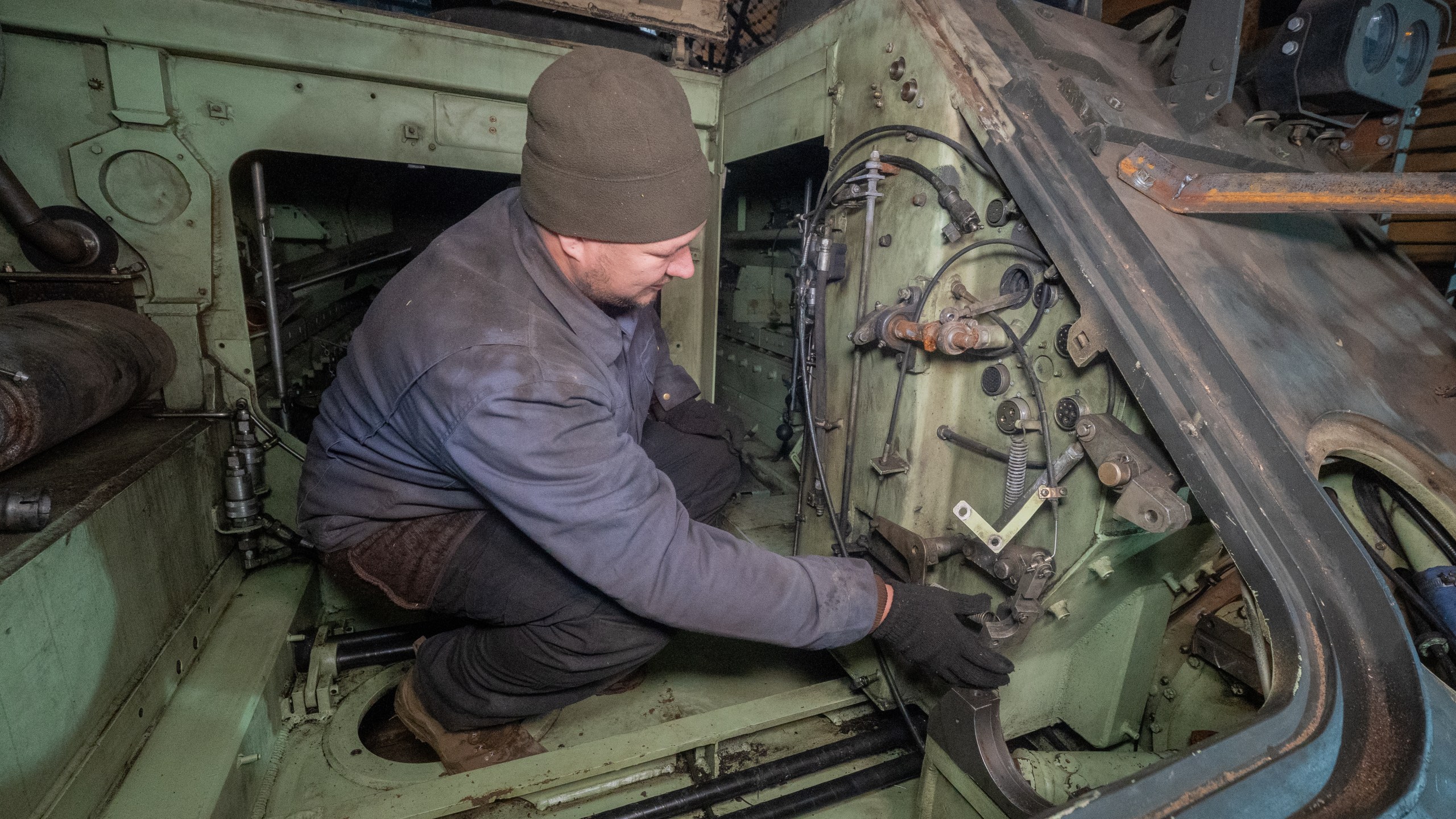 A Ukrainian soldier from repair and recovery battalion of the 57th separate brigade repairs an armoured personnel carrier (APC) outskirts Kharkiv, Ukraine, Monday, Oct. 20, 2025. (AP Photo/Andrii Marienko)