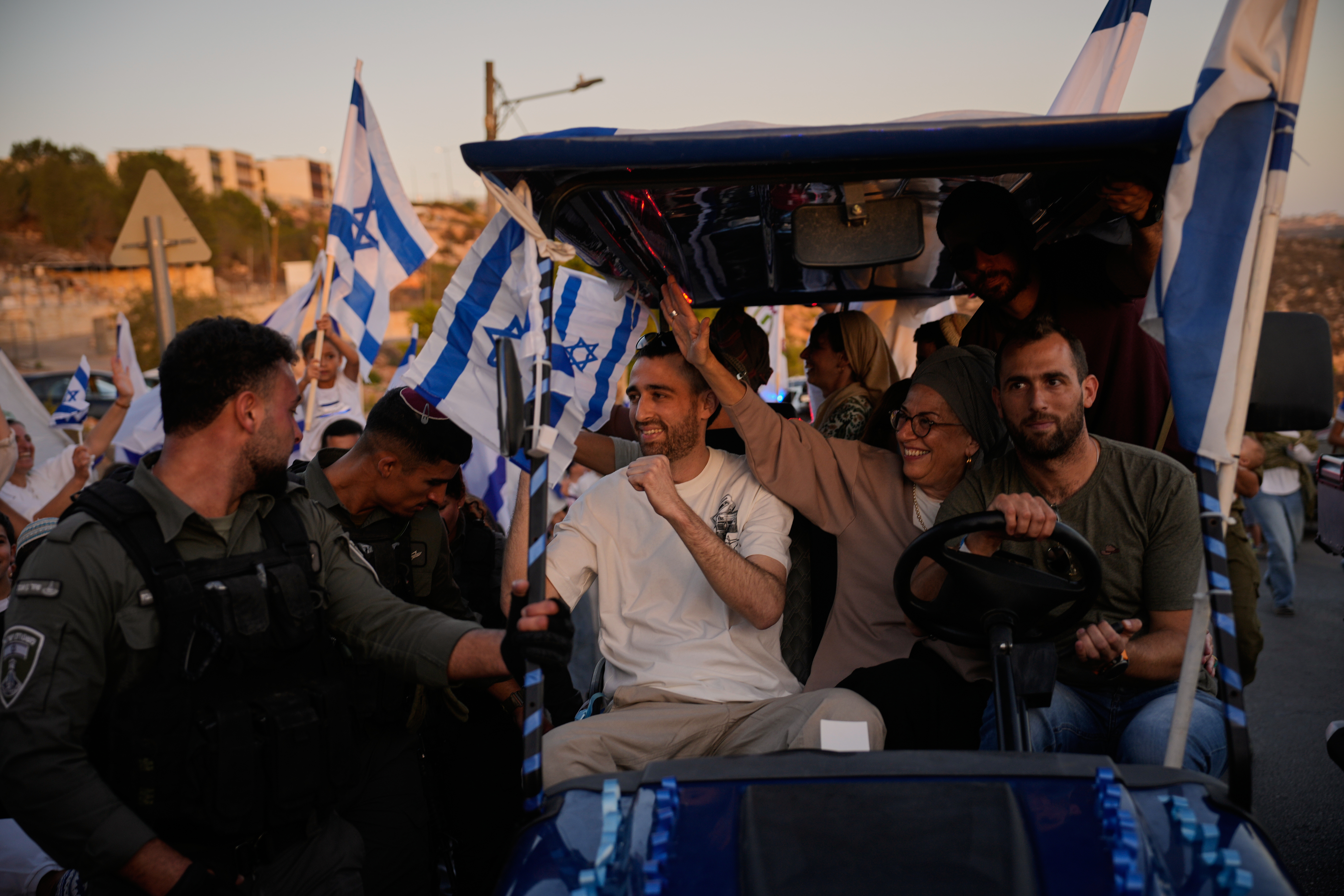 Freed hostage, Avinatan Or, center, who was recently released from Hamas captivity in Gaza, is welcomed as he return from the hospital to his home in the West Bank Jewish settlement of Shilo, Tuesday, Oct. 21, 2025. (AP Photo/Ohad Zwigenberg)