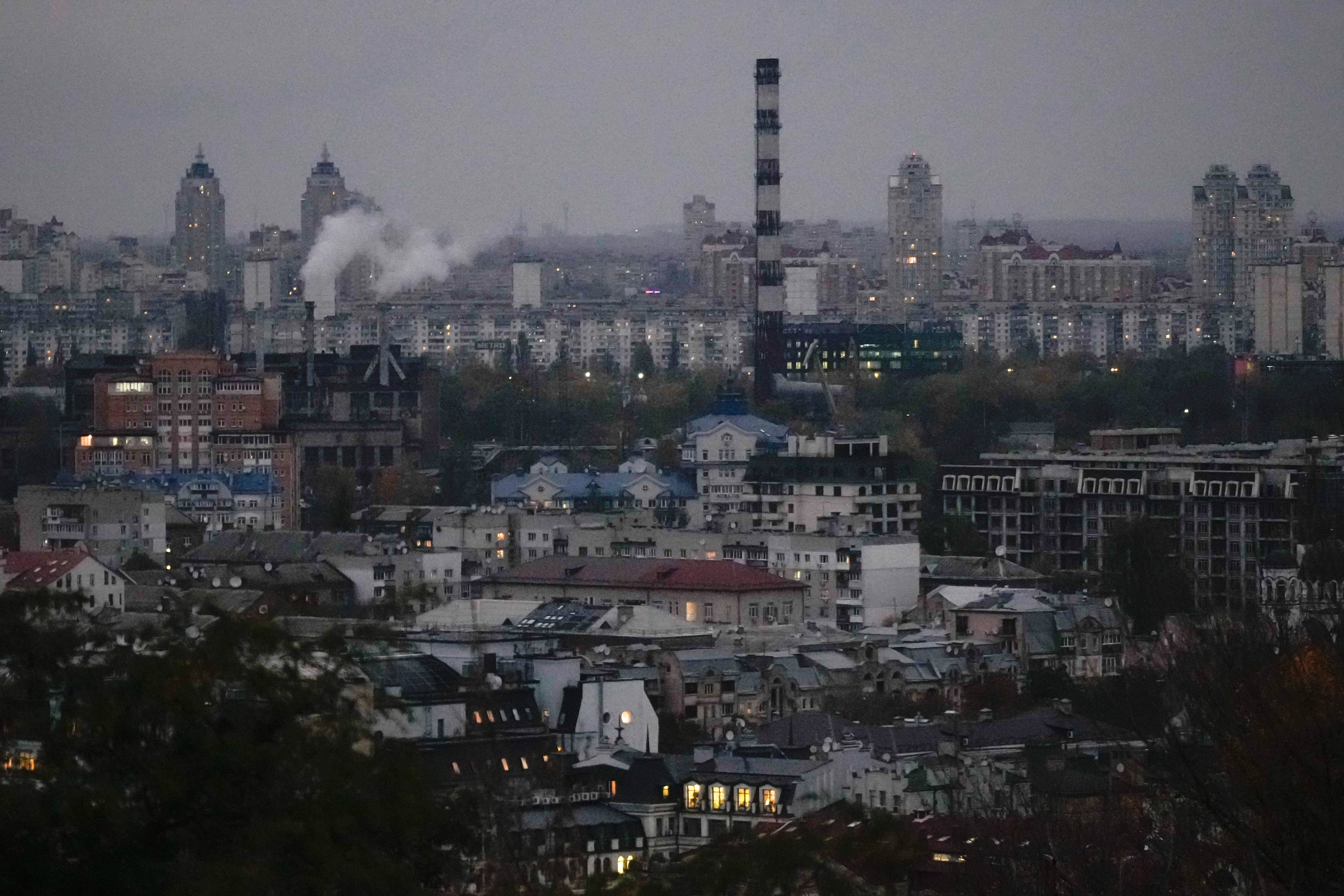 Smoke bellows in the background at dusk in Kyiv, Ukraine, Tuesday, Oct. 21, 2025. (AP Photo/Julia Demaree Nikhinson)