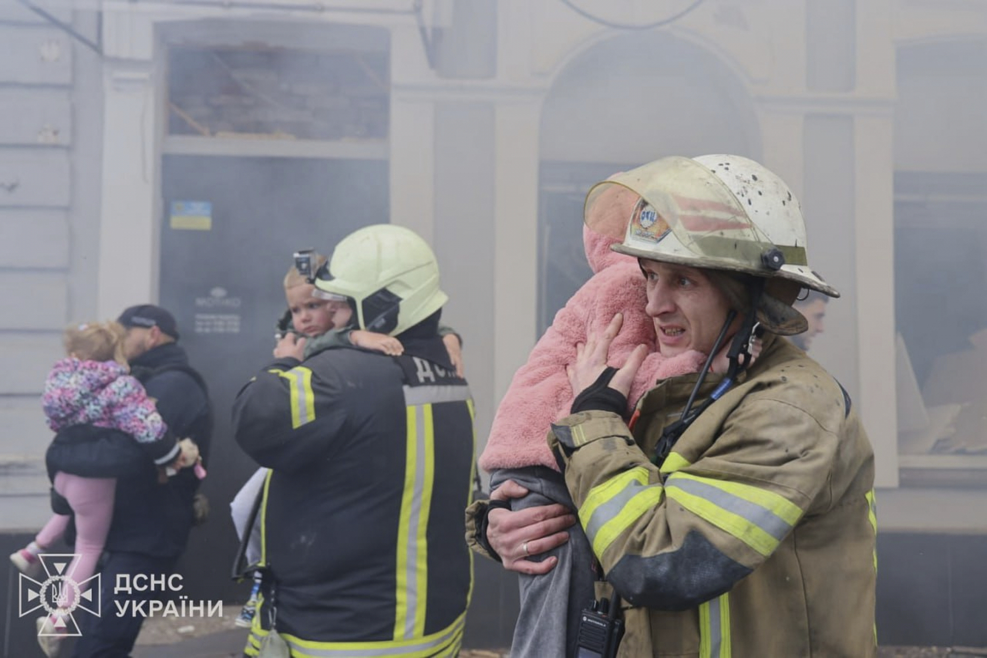 In this photo provided by the Ukrainian Emergency Service, rescuers evacuate children after Russian drones hit a city kindergarten during an attack in Kharkiv, Ukraine, Wednesday, Oct. 22, 2025. (Ukrainian Emergency Service via AP)