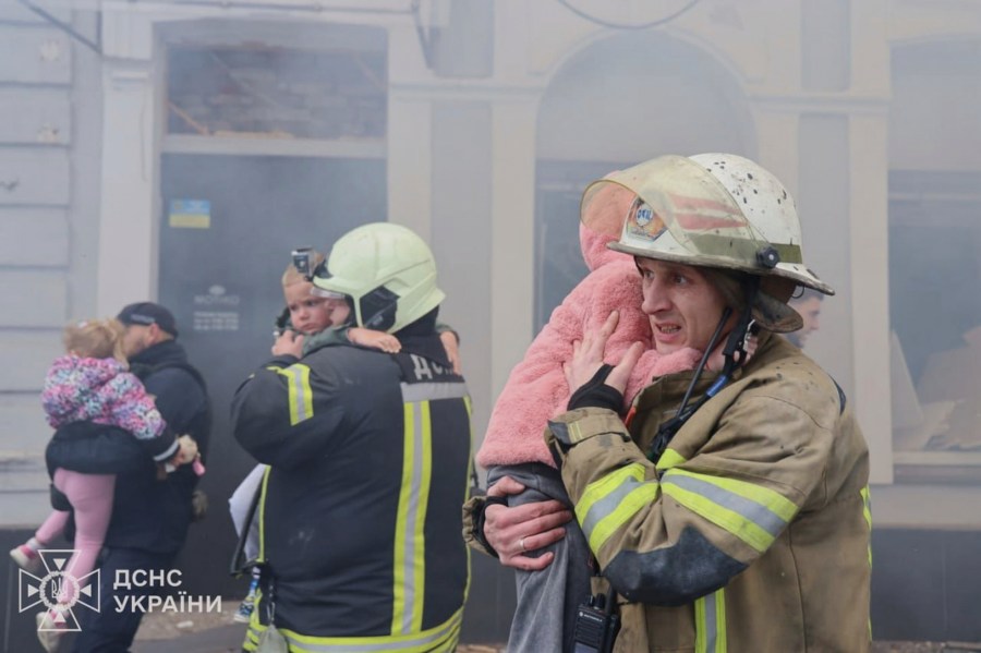 In this photo provided by the Ukrainian Emergency Service, rescuers evacuate children after Russian drones hit a city kindergarten during an attack in Kharkiv, Ukraine, Wednesday, Oct. 22, 2025. (Ukrainian Emergency Service via AP)