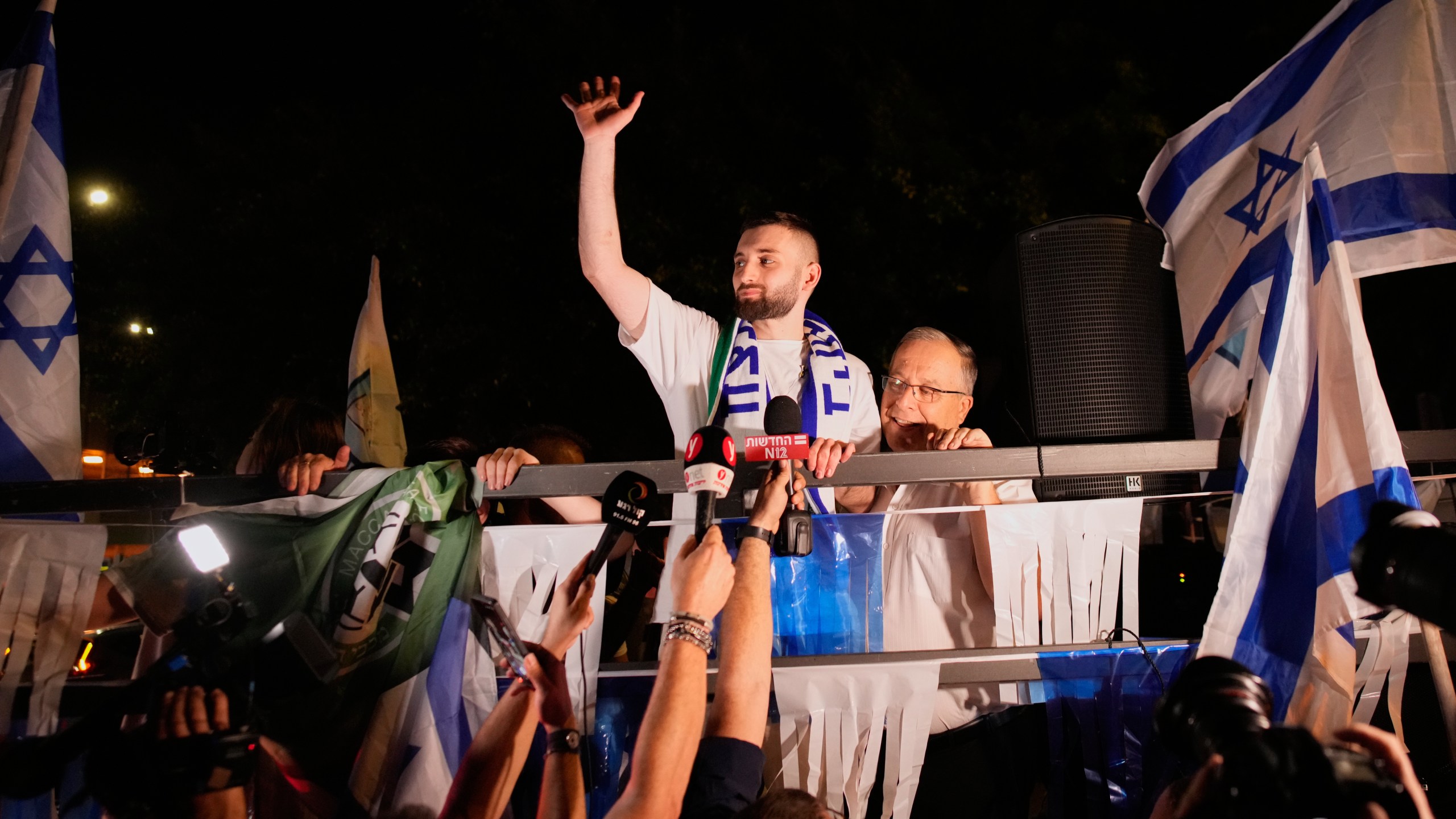 Freed Israeli hostage Matan Angrest, center, who was recently released from Hamas captivity in Gaza, greets supporters upon returning home to Kiryat Bialik, Israel, from the hospital, Thursday, Oct. 23, 2025. (AP Photo/Ohad Zwigenberg)