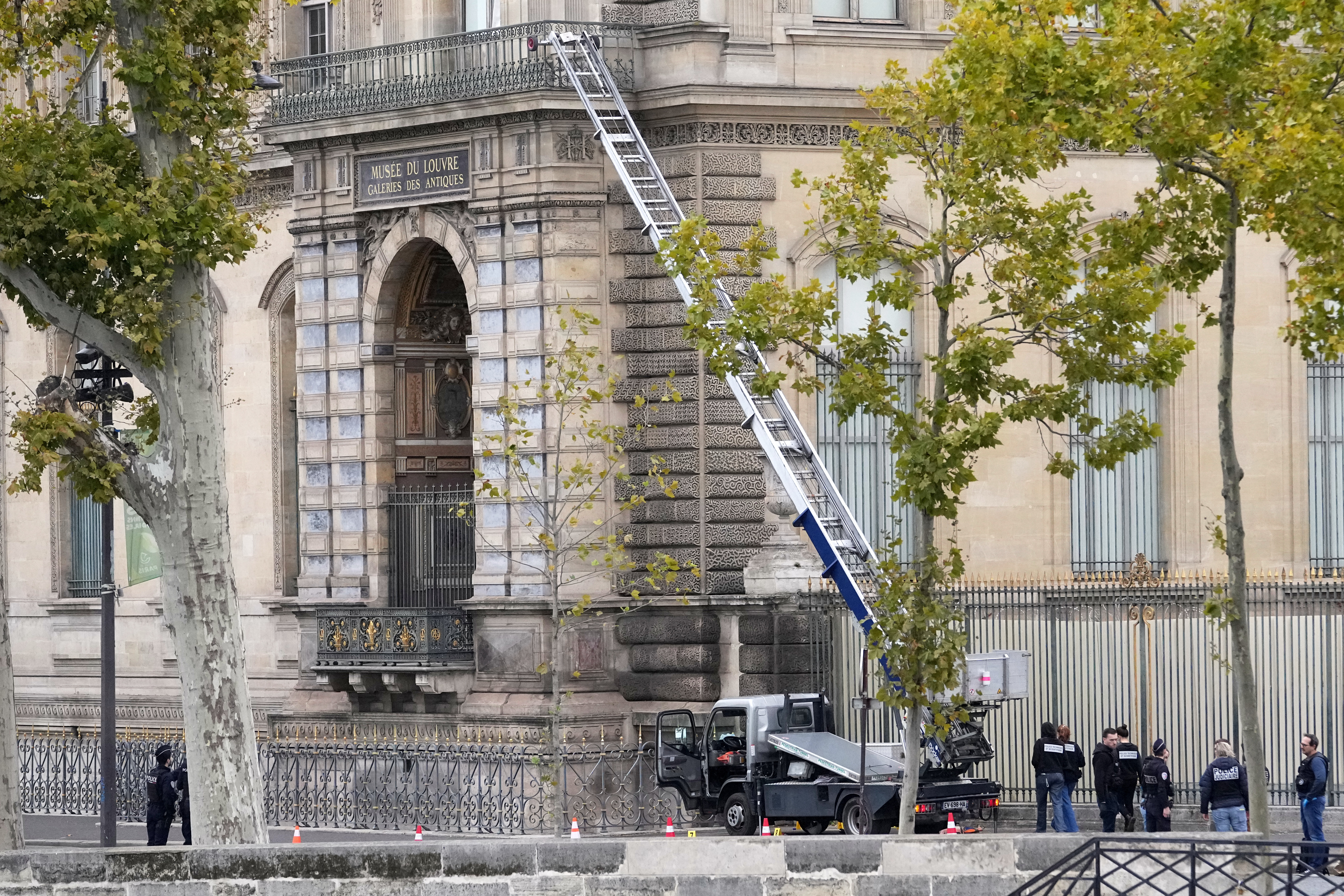 Police officers work by a basket lift used by thieves Sunday, Oct. 19, 2025 at the Louvre museum in Paris. (AP Photo/Thibault Camus)