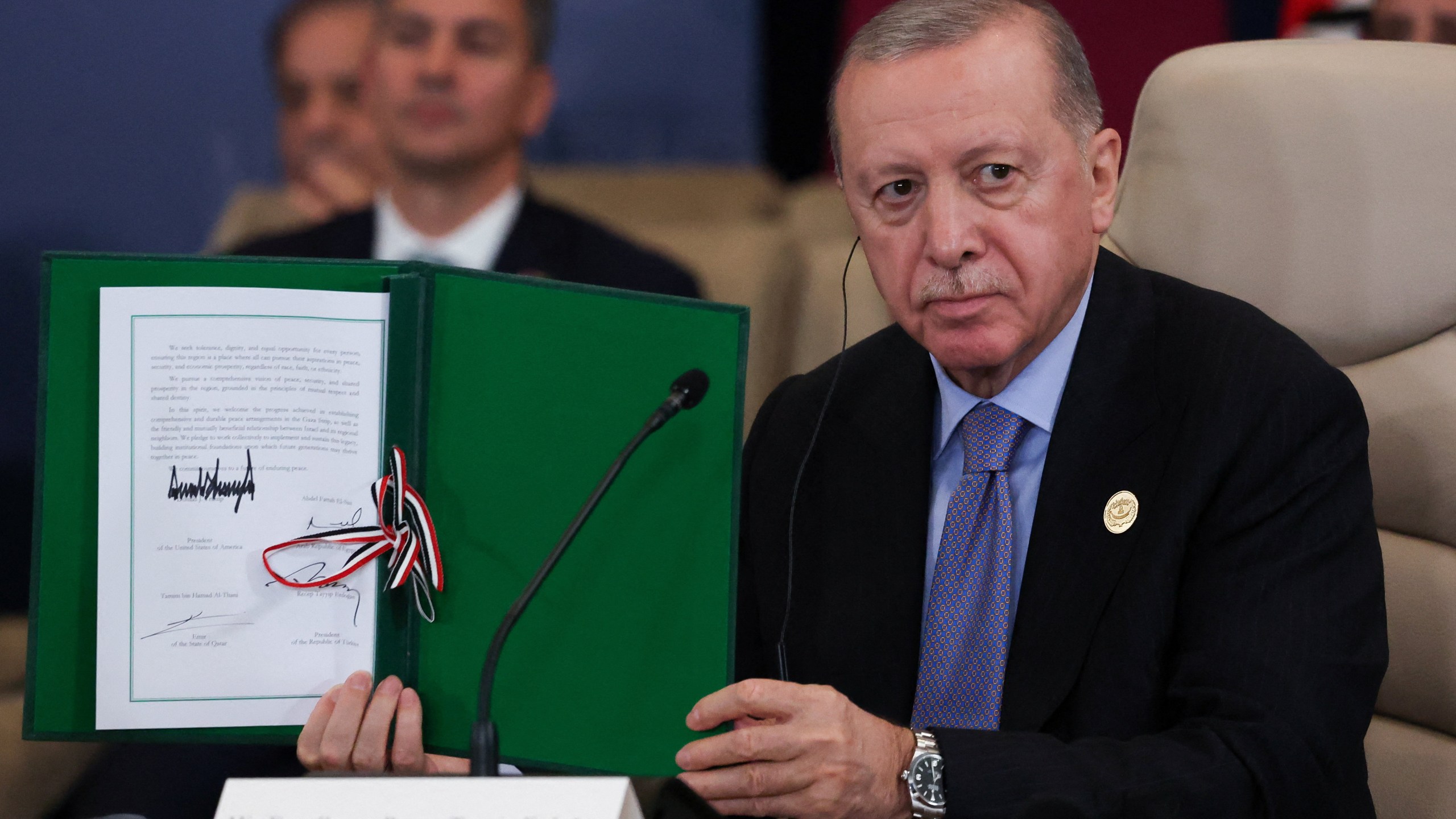 Turkey's President Recep Tayyip Erdogan holds a signed document during a summit to support ending the more than two-year Israel-Hamas war in Gaza after a breakthrough ceasefire deal, Monday, Oct. 13, 2025, in Sharm El Sheikh, Egypt. (Suzanne Plunkett/Pool via AP)