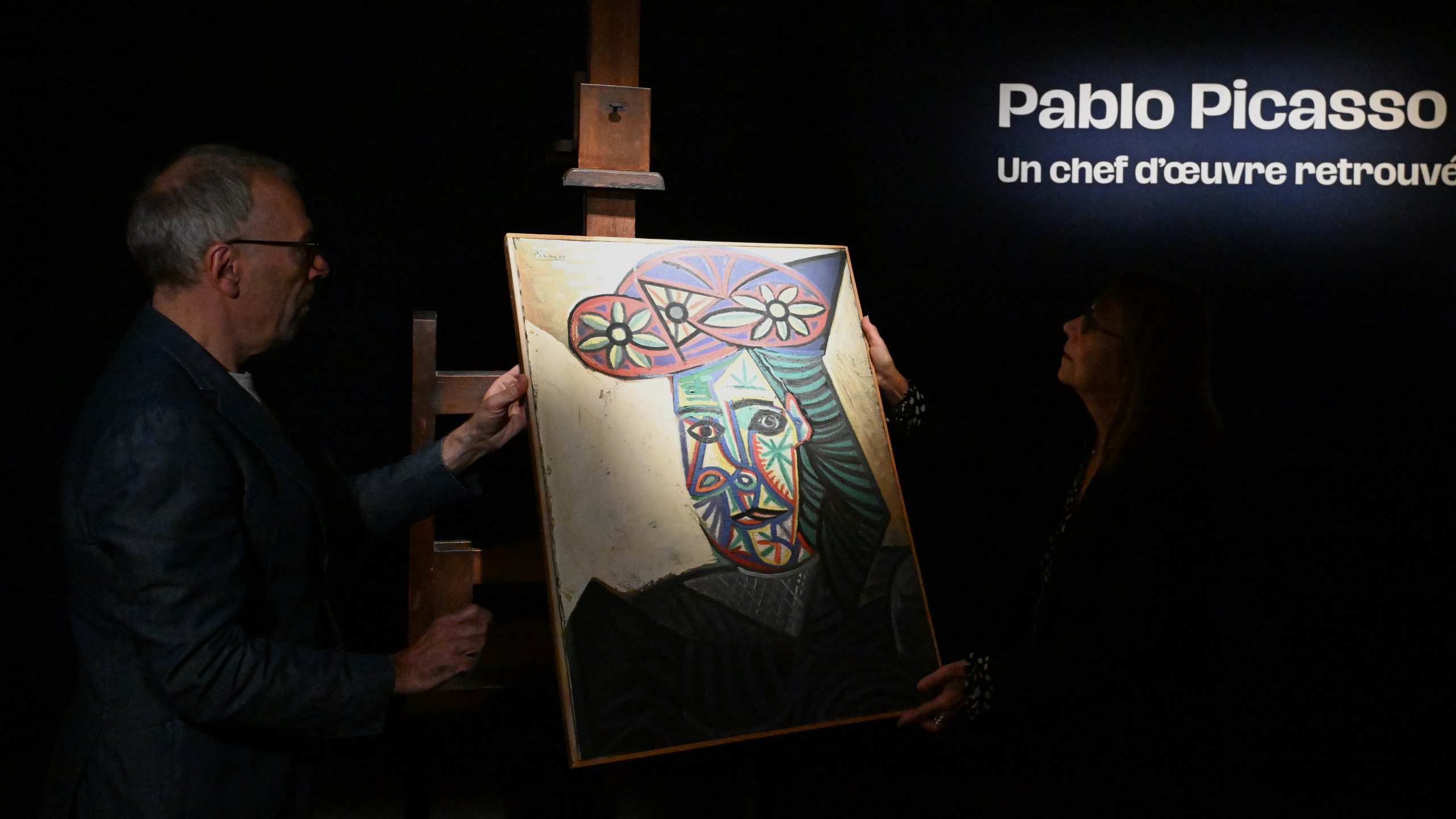 Art expert Agnes Sevestre-Barbe, right, and auction officer Christophe Lucien, stand by a rediscovered Picasso painting "Bust of a Woman in a Flowery Hat", Wednesday, Oct. 22, 2025 in Paris. The portrait painted in 1943 will be sold at auction Friday in Paris, was bought in 1944 and shows his partner Dora Maar. (AP Photo/Emma Da Silva)