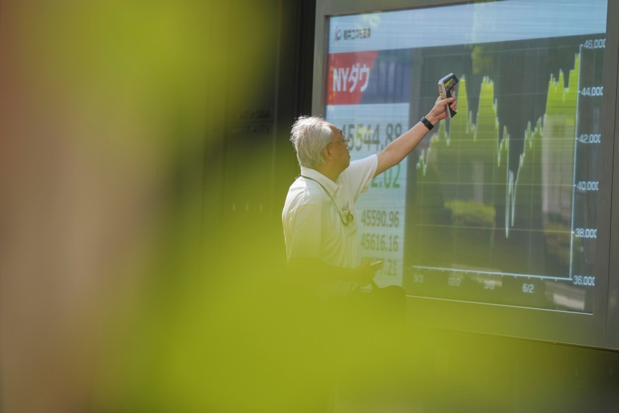 FILE -A staff check an electronic stock board prior to the opening of the stock market of the day at a securities firm Sept. 1, 2025, in Tokyo. (AP Photo/Eugene Hoshiko), File)