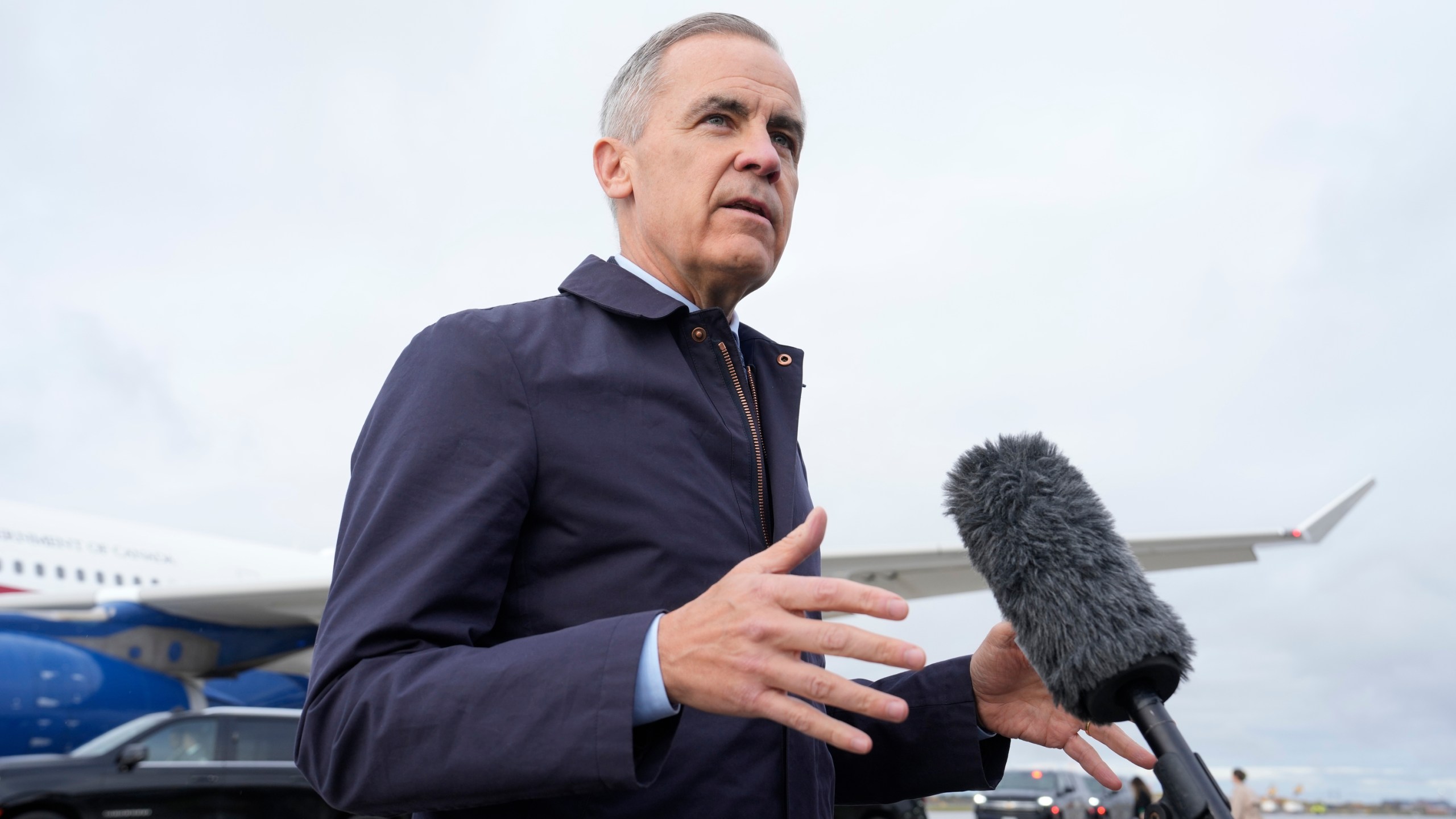 Canada Prime Minister Mark Carney speaks with members of the media before he boards a government plane in Ottawa on Friday Oct. 24, 2025. (Adrian Wyld/The Canadian Press via AP)
