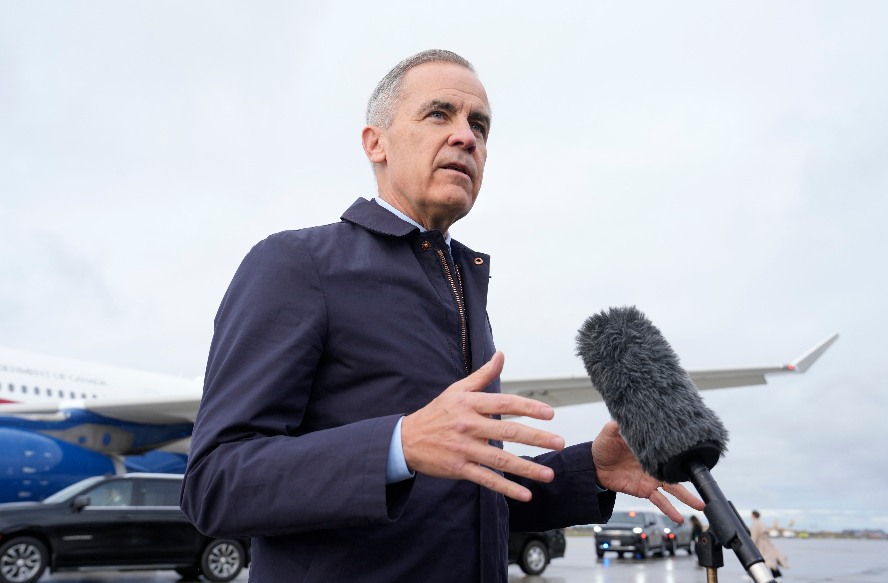 Canada Prime Minister Mark Carney speaks with members of the media before he boards a government plane in Ottawa on Friday Oct. 24, 2025. (Adrian Wyld/The Canadian Press via AP)