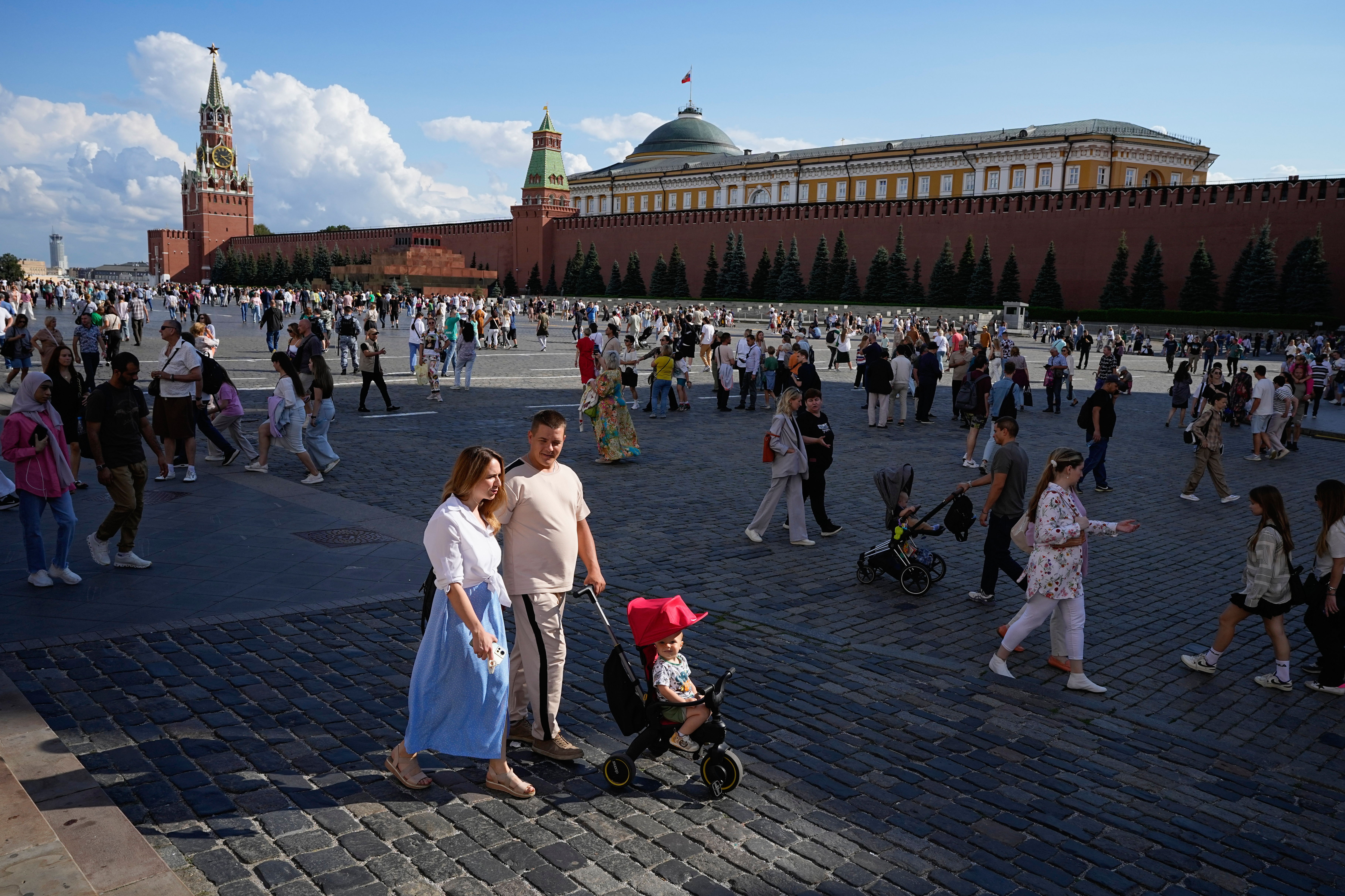 FILE - A family walks through Red Square in Moscow, Russia, Sunday, Aug. 4, 2024. (AP Photo/Alexander Zemlianichenko, File)