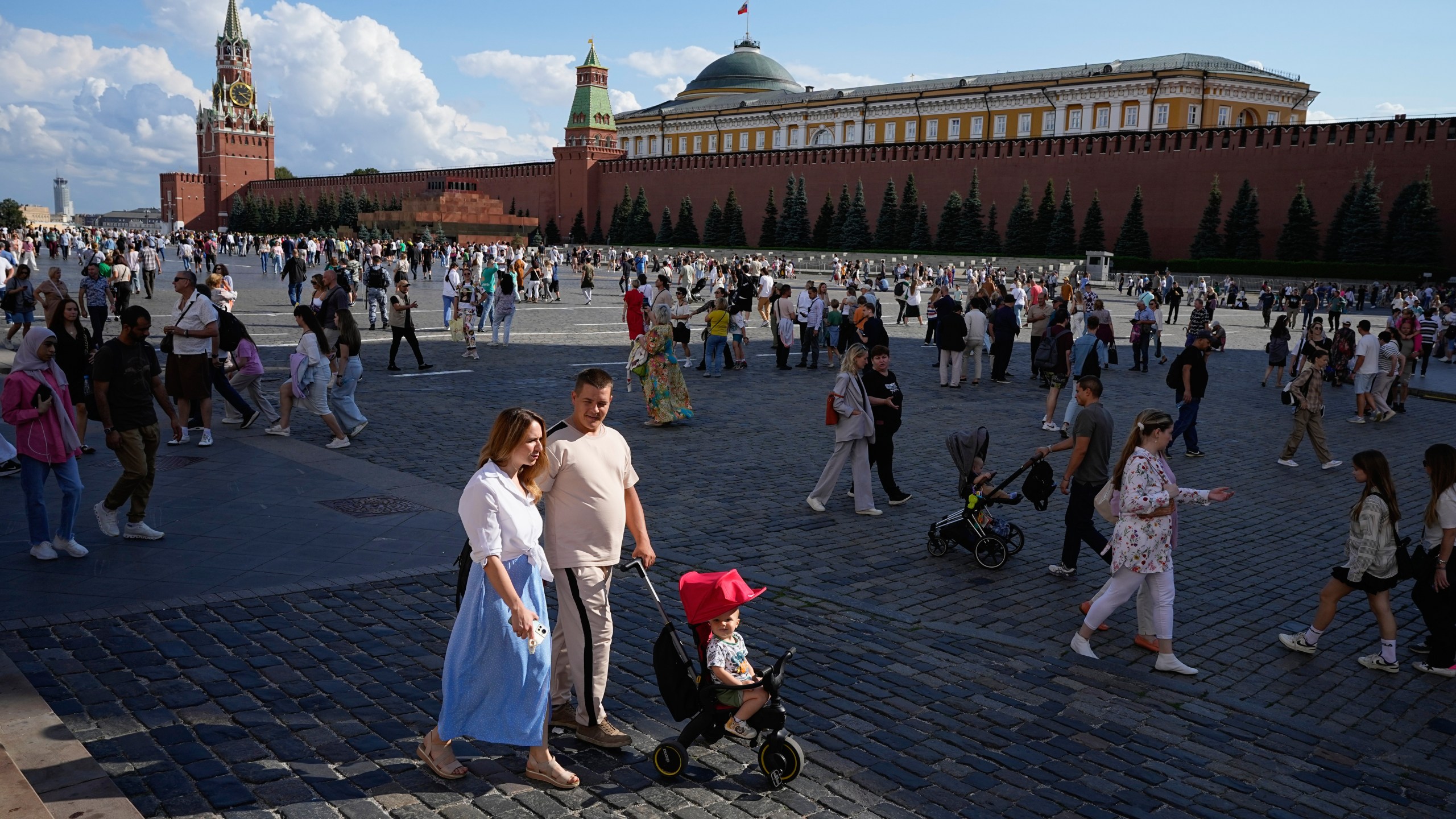 FILE - A family walks through Red Square in Moscow, Russia, Sunday, Aug. 4, 2024. (AP Photo/Alexander Zemlianichenko, File)