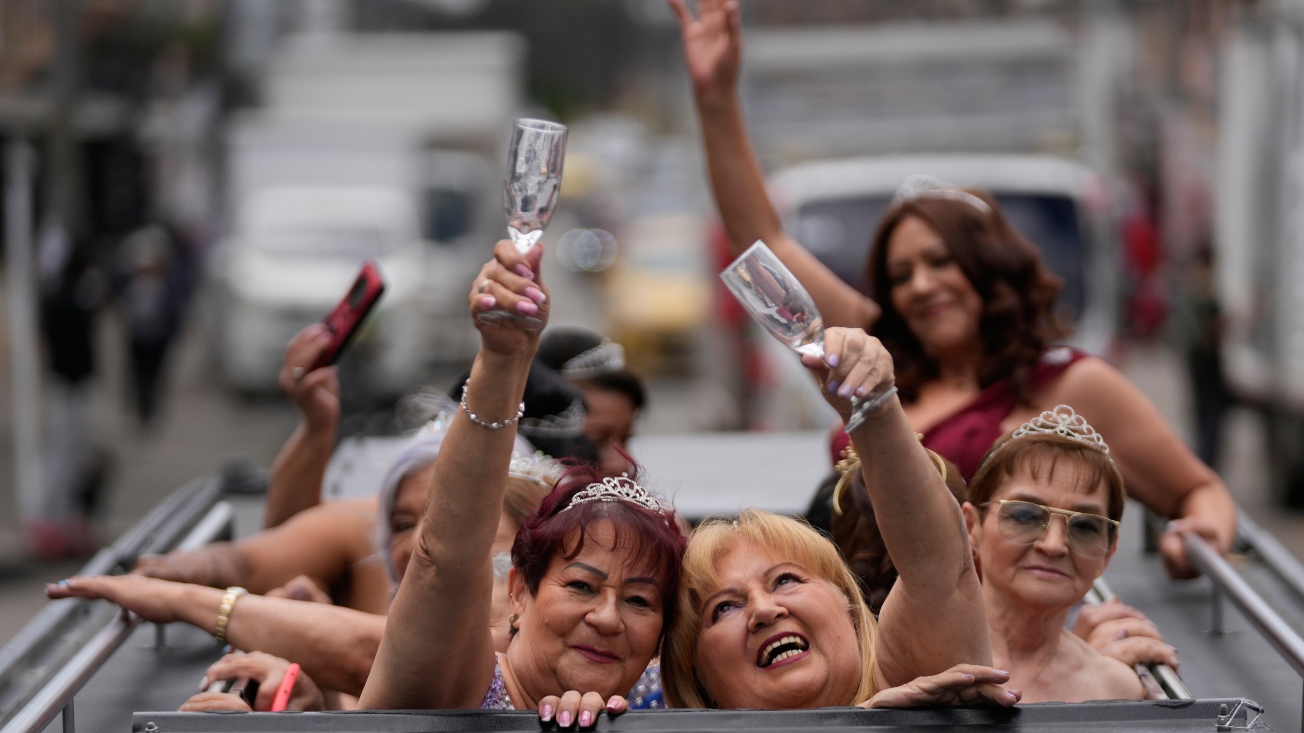 Blanca Guerrero, 67, left, and Gloria Sanabria, 67, right, ride in a limousine to a quinceanera celebration for women who never had a traditional 15th birthday party, organized by the Suenos Hechos foundation in Bogota, Colombia, Friday, Oct. 24, 2025.(AP Photo/Fernando Vergara)