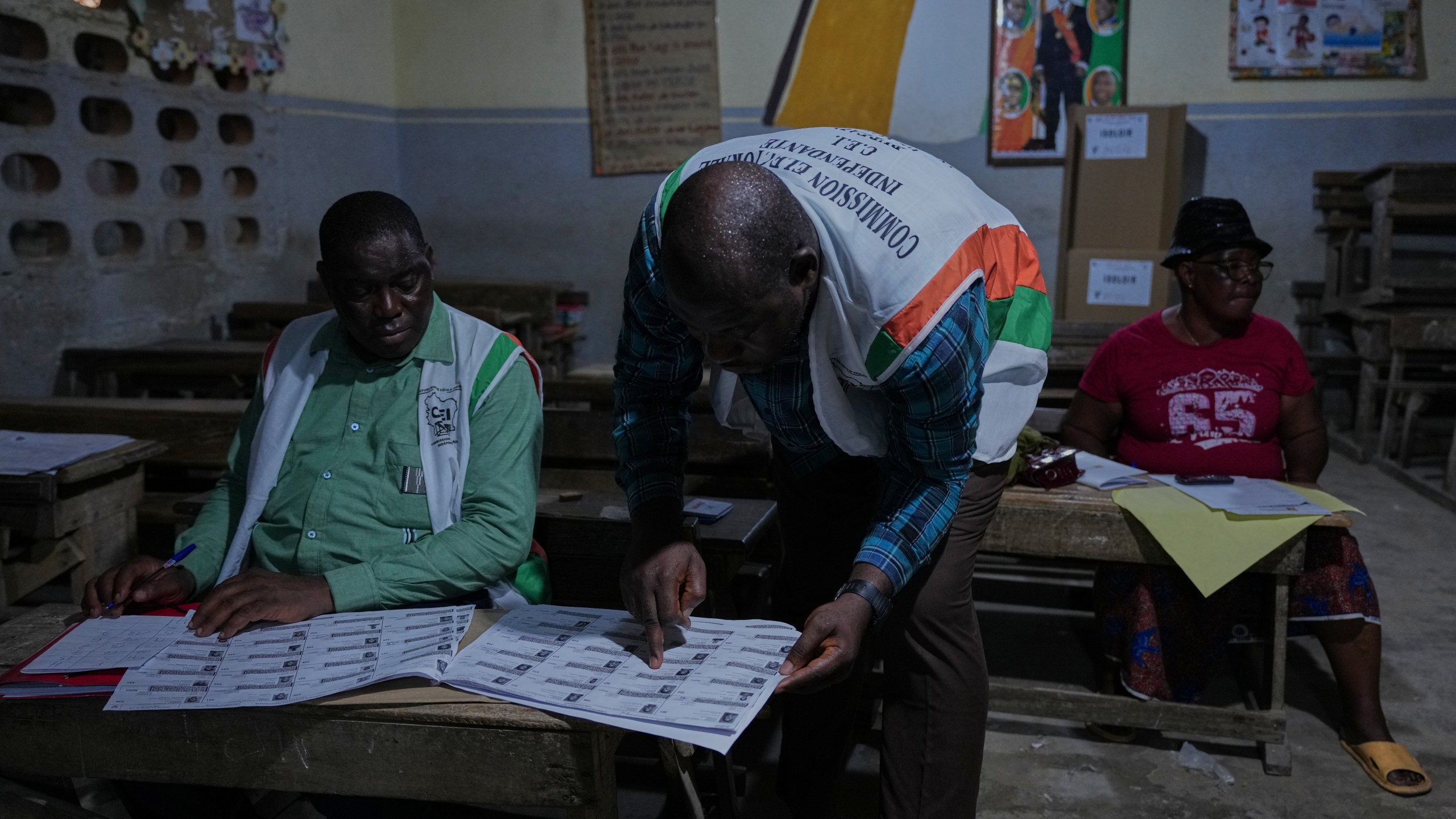 Officials count votes at a polling station in the Yopougon suburb of Abidjan, Ivory Coast, Saturday, Oct. 25, 2025, as polls close during the presidential elections. (AP Photo/Misper Apawu)