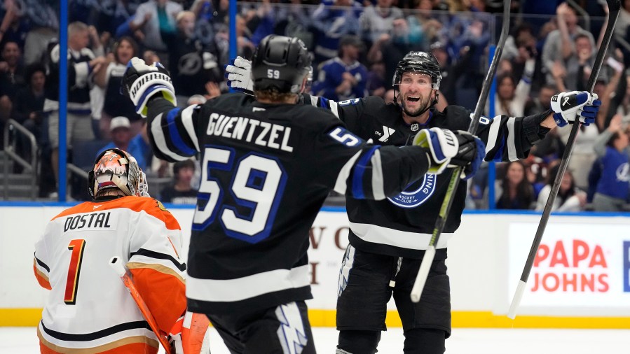 Tampa Bay Lightning right wing Nikita Kucherov, right, celebrates with center Jake Guentzel after picking up an assist for his 1,000th career point on a goal by center Brayden Point on Anaheim Ducks goaltender Lukas Dostal (1) during the second period of an NHL hockey game Saturday, Oct. 25, 2025, in Tampa, Fla. (AP Photo/Chris O'Meara)