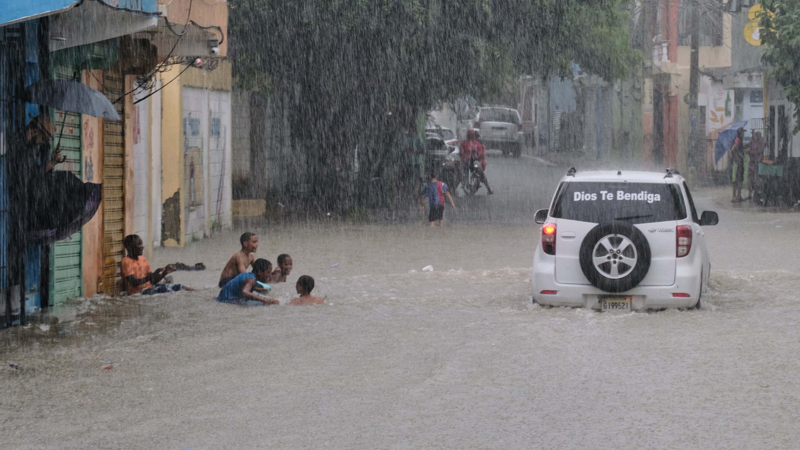 Children play in a street flooded by rains caused by Tropical Storm Melissa in Santo Domingo, Dominican Republic, Friday, Oct. 24, 2025. (AP Photo/Ricardo Hernandez)