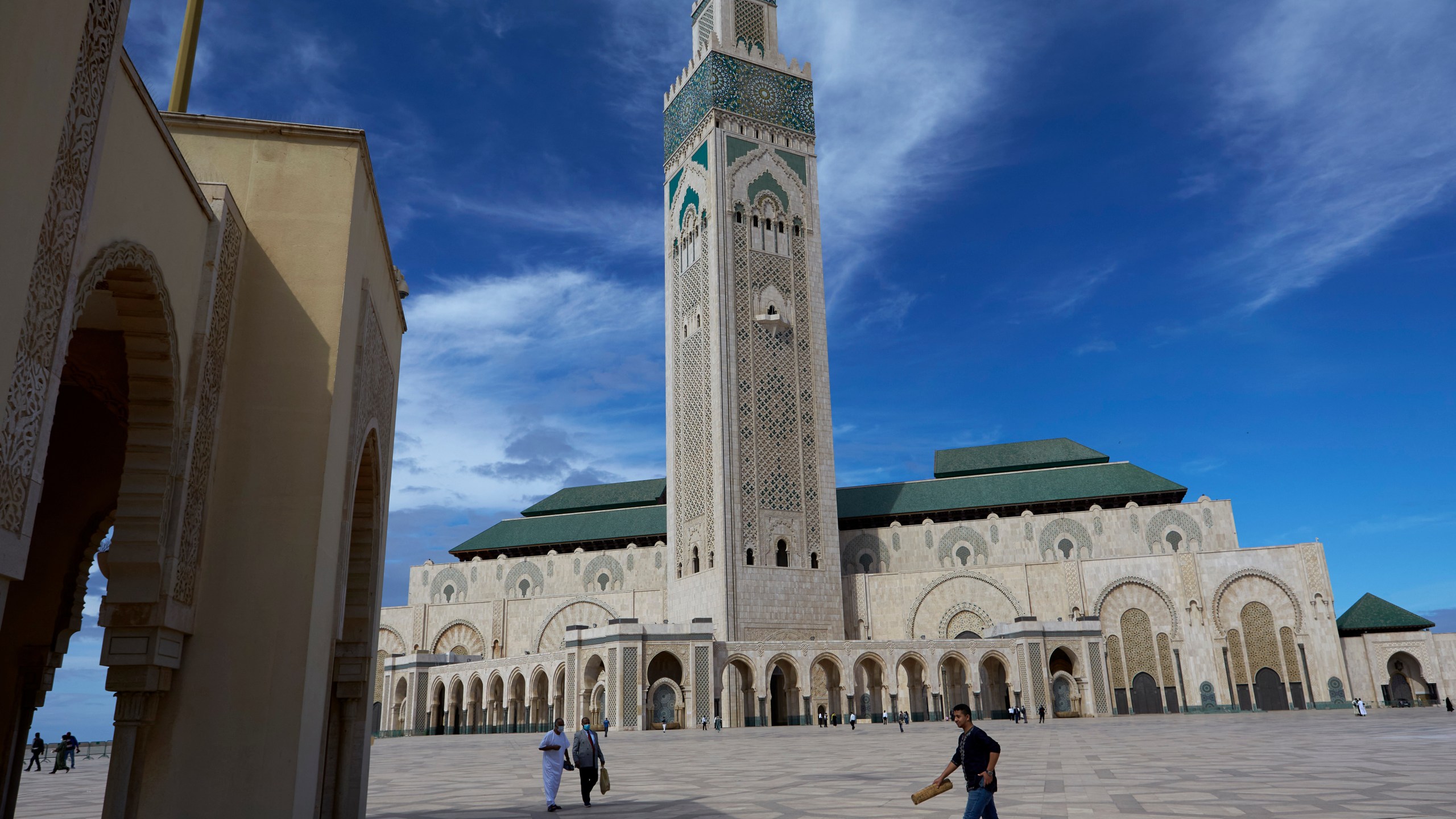 FILE - People walk past the great Hassan II Mosque in Casablanca, Morocco, Oct. 16, 2020. (AP Photo/Abdeljalil Bounhar, File)