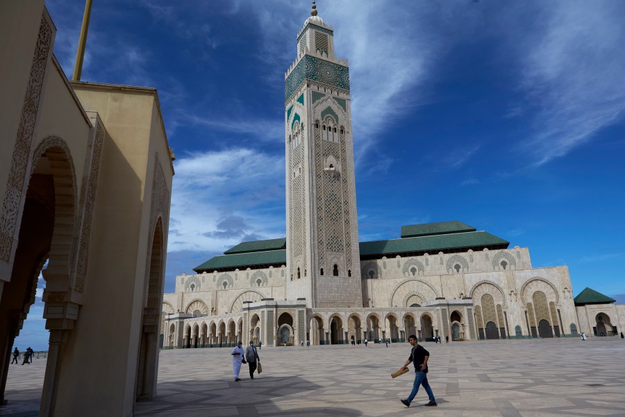 FILE - People walk past the great Hassan II Mosque in Casablanca, Morocco, Oct. 16, 2020. (AP Photo/Abdeljalil Bounhar, File)