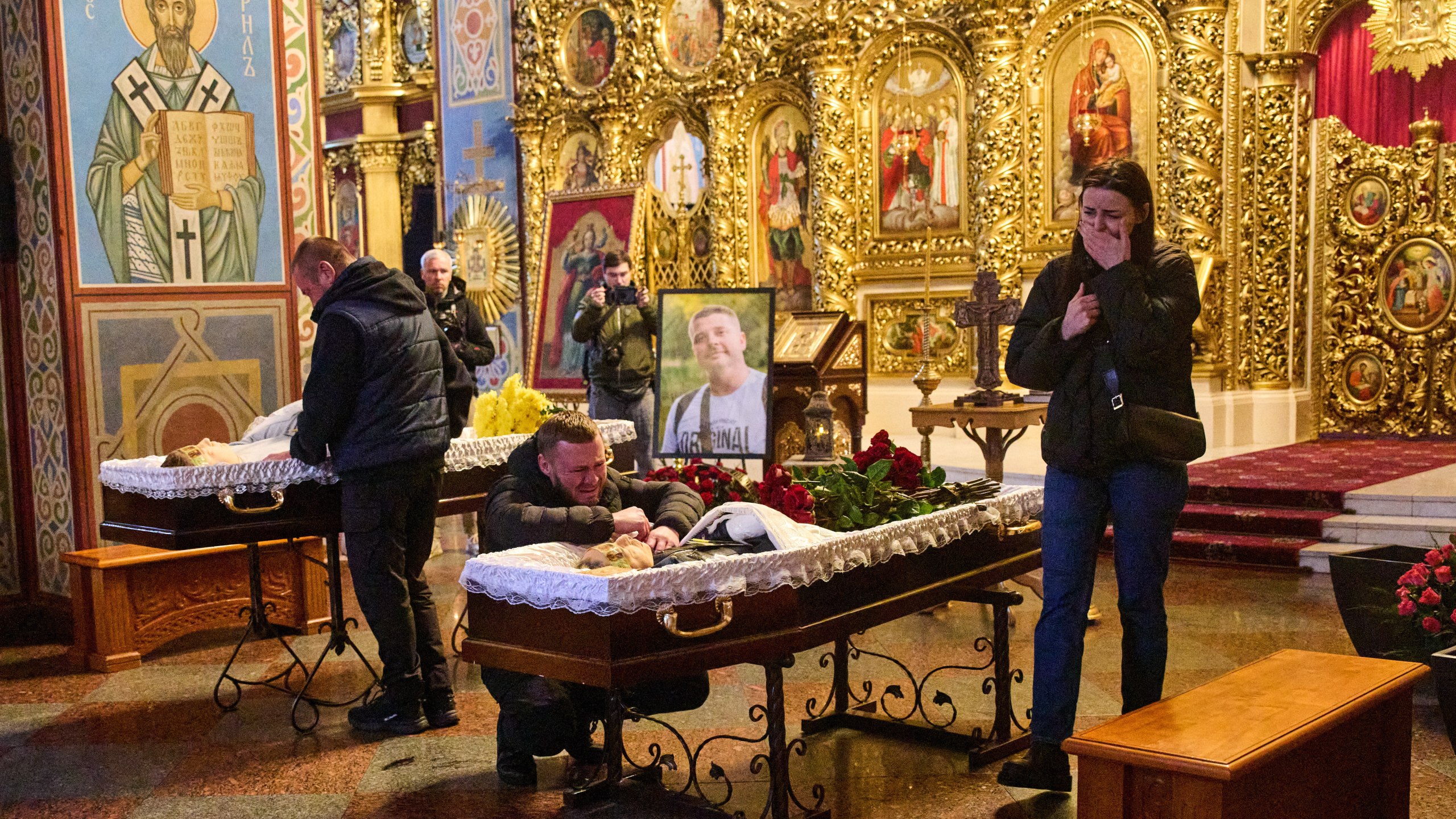 Relatives, colleagues and friends of two Ukrainian 43-year-old journalists Olena Hubanova, who worked under the pseudonym Alyona Gramova, and cameraman Yevhen Karmazin, who were killed on Thursday, Oct. 23, when a Russian Lancet drone hit their vehicle in Ukraine's Kramatorsk around 20 kilometres from the front line, mourn over their coffins during a funeral service at St. Michael Monastery in Kyiv, Ukraine, Monday, Oct. 27, 2025. (AP Photo/Efrem Lukatsky)