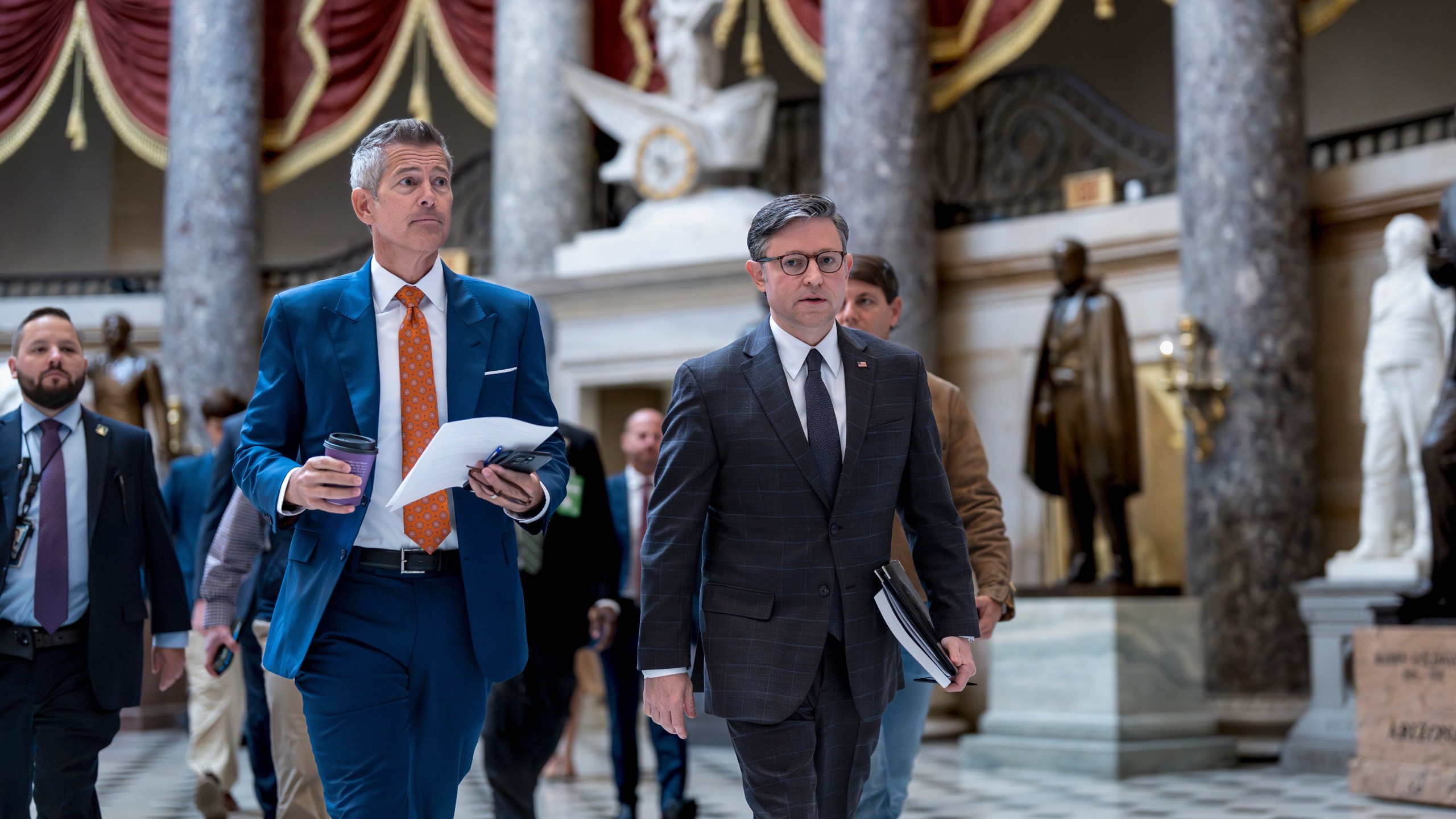 Transportation Secretary Sean Duffy, left, and Speaker of the House Mike Johnson, R-La., walk through Statuary Hall at the Capitol to a news conference on day 23 of the government shutdown, in Washington, Thursday, Oct. 23, 2025. (AP Photo/J. Scott Applewhite)