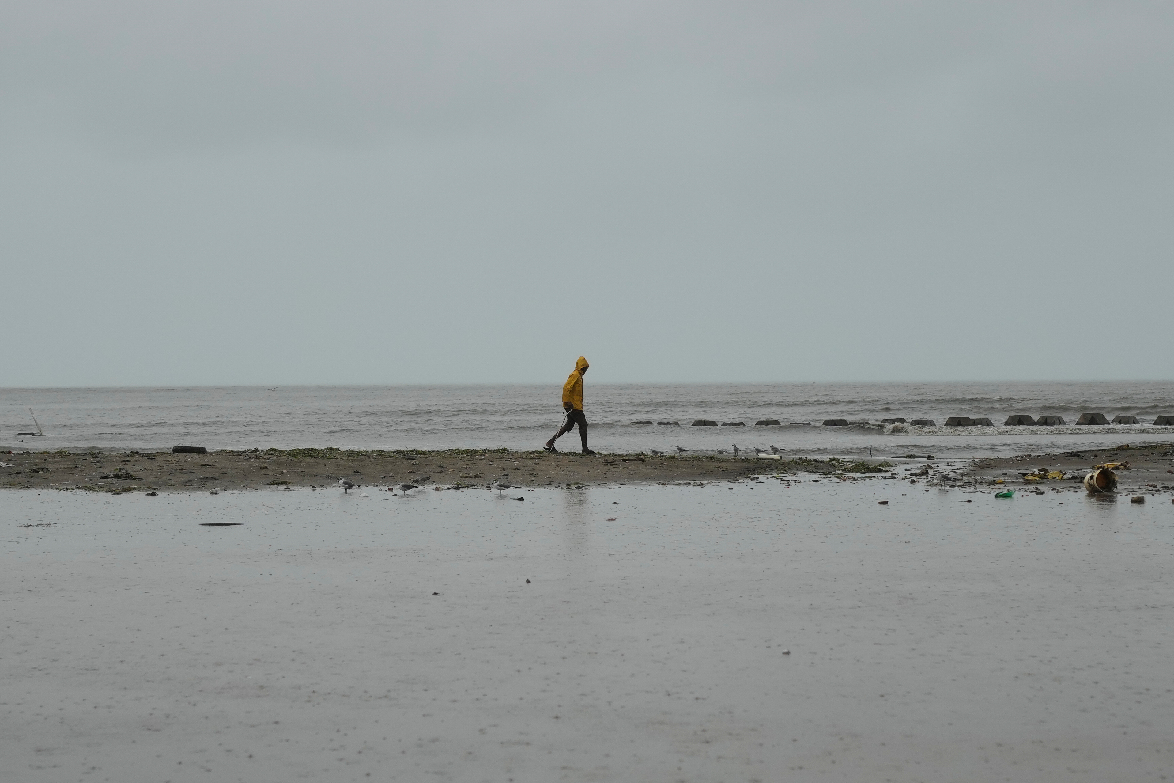 A man walks along the coastline ahead of the forecasted arrival of Hurricane Melissa in Old Harbour, Jamaica, Monday, Oct. 27, 2025. (AP Photo/Matias Delacroix)