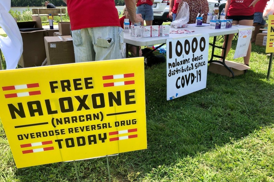 FILE - Signs are displayed at a tent during a health event June 26, 2021, in Charleston, W.Va. (AP Photo/John Raby, File)